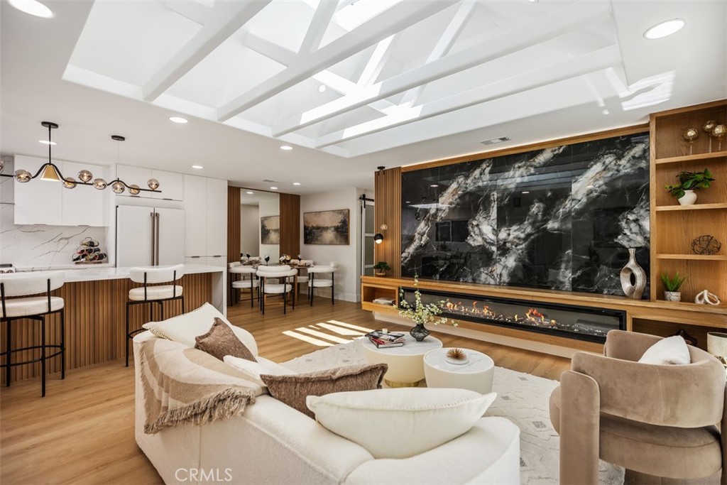 Experience unparalleled luxury in this impeccably remodeled, move-in-ready home that seamlessly blends sophistication with modern comfort. From the moment you step inside, you're greeted by an abundance of natural light and breathtaking media/fireplace wall that creates an inviting and serene ambiance. The sunny patio serves as a versatile space, perfect for relaxation or entertaining guests. The home's transformation includes a comprehensive renovation featuring central HVAC and a series of bespoke architectural enhancements. Notably, the living room boasts a stunning skylight and a custom wood and tile media surround, complemented by tailored lighting solutions. The residence exudes warmth and elegance throughout. The gourmet kitchen is a chef's dream, equipped with custom cabinetry, quartz countertops, and top-of-the-line appliances and fixtures. A generous waterfall-style island provides ample counter space and serves as a central hub for social gatherings. Retreat to the luxurious master suite, thoughtfully designed en-suite bathroom features a spacious, custom-tiled shower and premium appointments, offering a spa-like experience. Additional highlights include abundant built-in storage solutions and a conveniently located stackable washer and dryer in the hall closet. Parking is easily accessible, adding to the home's convenience. Residents of Laguna Woods Village enjoy access to an array of exceptional amenities, including golf, swimming, tennis, and a vibrant selection of clubs and social activities, all within a premier 55+ community. For a comprehensive view of this remarkable home, please click on the 360 Virtual Tours (VT) link.