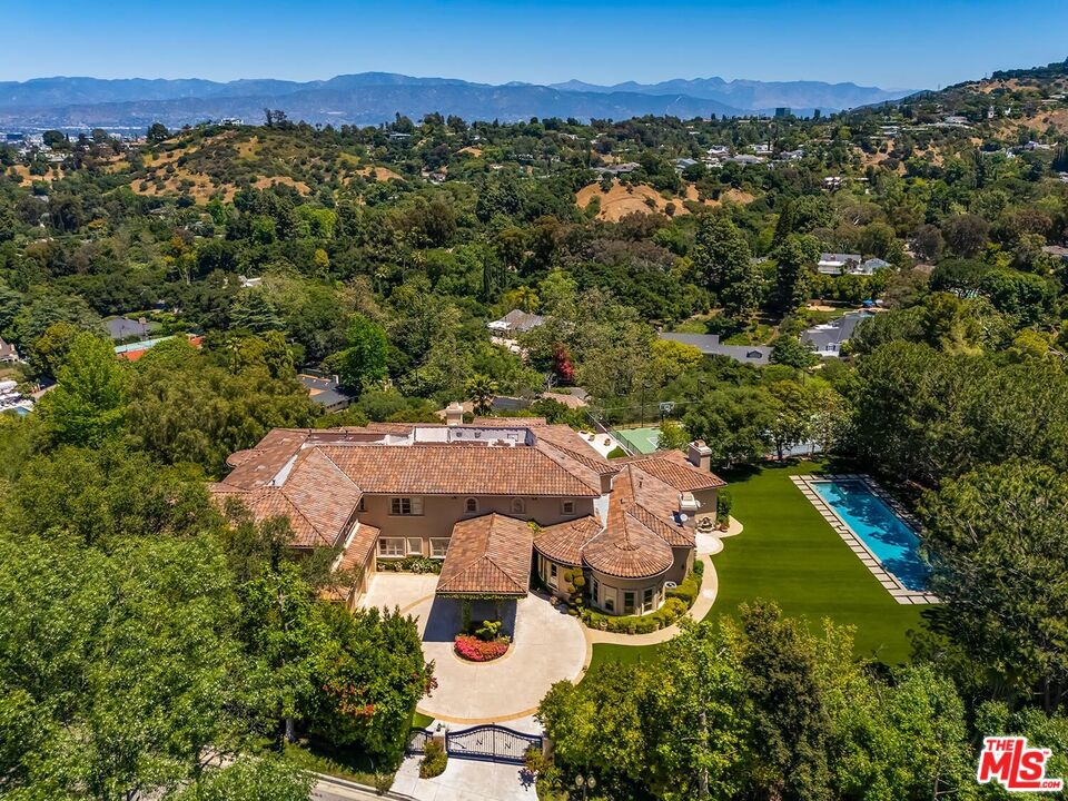Remarkable long-term lease on this double-gated ultra-secluded 2002-built 2sty manse on the most exclusive gated private road of only 4 homes in Fryman Estates set on a majestic 2.4 acre (mostly usable) lot with sweeping city/canyon/hilltop/treetop views. Voluminous scale with super high ceilings, light-filled rooms, and endless grounds including a fabulous pool/spa and lighted full-size tennis court all taking perfect advantage of the unobstructed views. From the circular motorcourt, one enters into the dramatic 2sty dual-staircase skylit foyer leading to a gracious paneled library/office, living room/salon, formal dining room, and huge family room with bar and wine storage. Massive chef's kitchen with breakfast room and walk-in pantry overlooks and opens to the grounds and views. Primary retreat contains a sitting room, bar, fireplace, sauna, dual baths with large walk-ins, and views. 4 other generous bedroom suites upstairs along with a large secondary family room. 2 guest bedroom suites downstairs. As a functional bonus space, a nearly 500 sq ft gym/studio/flex space with outdoor and garage entryways exists downstairs. Direct access 3-car garage with EV charger capability. Moments from studios, shopping, dining, entertainment, hiking trails, and all other Studio City amenities, this is the ultimate long-term lease for 2025 and beyond. Shown to highly pre-qualified tenants only.