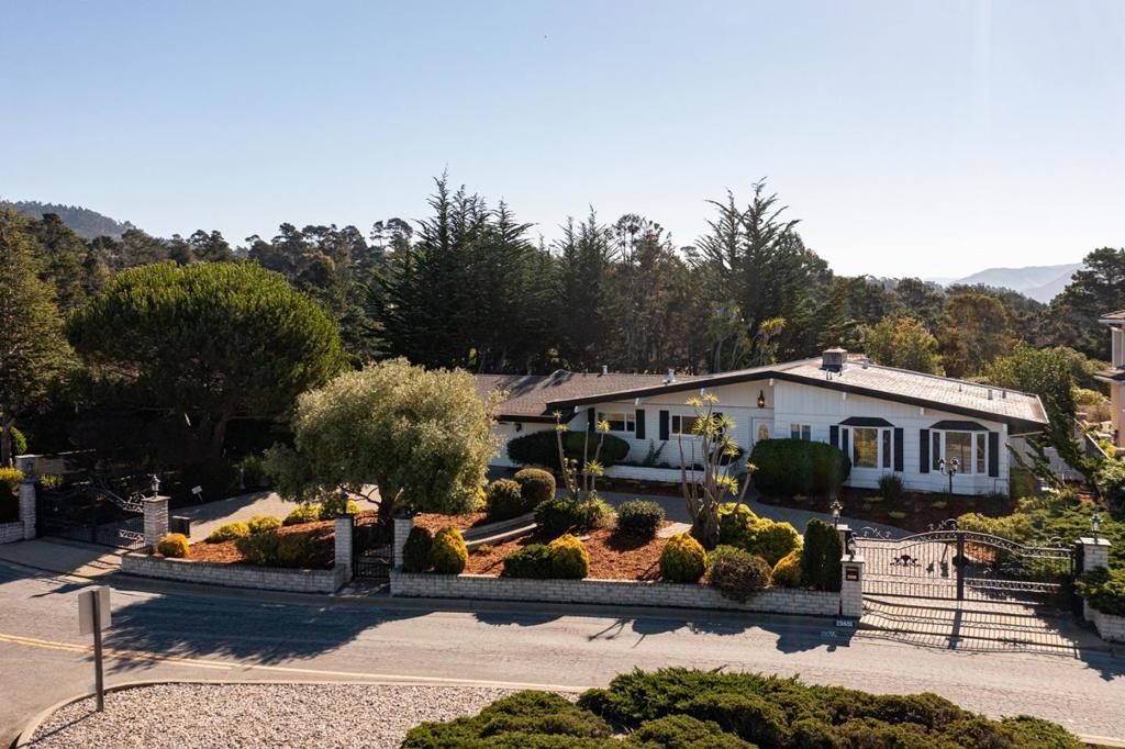 Nestled on the most coveted stretch of Carmel Knolls Drive, this beautifully maintained single-level ranch-style home offers just under 1,700 sq. ft. of comfortable, light-filled living space. Set on a sunny, level lot of over one-quarter acre, the home has been lovingly cared for by the same family for over 25 years and blends timeless charm with modern livability. Inside, you'll find hardwood floors, an open-beam ceiling and a spacious living and dining area with floor to ceiling windows. This room flows seamlessly to a private, expansive backyard that is perfect for entertaining, play, pets, or peaceful relaxation. The property sits behind a wide gated entrance with a gracious circular driveway and attached over-sized two-car garage, offering privacy, convenience, and standout curb appeal. Move-in ready, with a versatile floor plan full of potential to tailor to your lifestyle and your personal updates and custom touches. This home is located within the award-winning Carmel Unified School District and just minutes from Carmel's shops, restaurants, and beaches. Don't miss this rare opportunity to enjoy the best of Carmel living. Make it yours today!