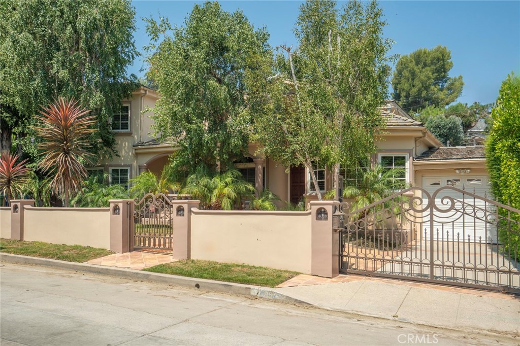 Furnished or Unfurnished!! Situated in a coveted South of Ventura location, this 4BR+5BA gated Mediterranean offers timeless elegance, perfectly suited for both everyday living and grand entertaining. From the moment you enter, the dramatic living room makes a statement with two-story beamed ceilings, skylights, and a striking fireplace. The formal dining room is ideal for hosting gatherings, featuring custom built-in cabinetry that adds character and functionality. A true showpiece, the gourmet kitchen was meticulously designed by a celebrity chef with entertaining in mind—complete with granite countertops, stainless steel appliances, a Viking six-burner stove with griddle and double oven, center island, custom cabinetry and a greenhouse window. The kitchen flows into a sunlit breakfast area and spacious family room with fireplace, built-in bar and wine cooler, all seamlessly opening to the stunning backyard. The main level features two ensuite bedrooms —including a generous secondary master suite with double sinks and french doors leading out to the yard. Upstairs, the primary suite is a true sanctuary. Enter through double doors to find a spacious haven with high ceilings, french doors, and a private balcony. The luxurious master bath offers double sinks, a spa tub, and an oversized shower, along with a dressing area featuring two vanities, an extra sink, and a huge walk-in closet. Step into the backyard and be transported to a private tropical paradise. Surrounded by lush foliage, the outdoor space is ideal for entertaining, with a resort-style pool and spa, covered patio, grassy yard and a cabana dining area. The outdoor chef's kitchen includes a built-in BBQ, two burners, deep fryer, sink, and a separate bar area- perfect for al-fresco gatherings. Set in a quiet section of Benedict Canyon Dr on a dead end street - not the busy stretch off Mulholland to Beverly Hills - this elegant Mediterranean retreat exudes a lifestyle of inspired living.