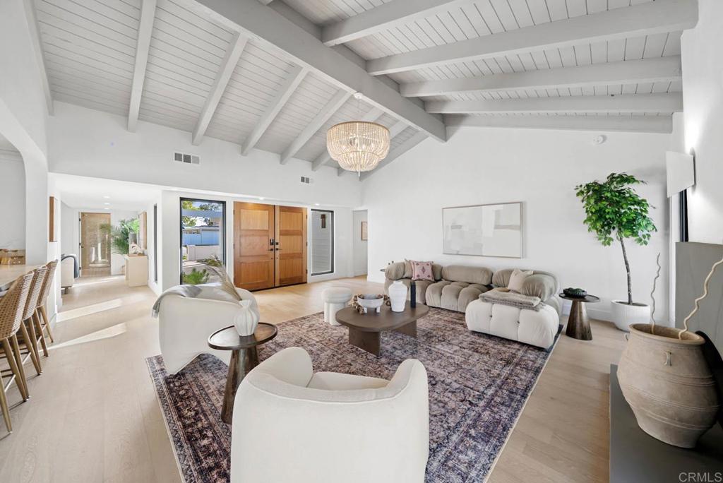 Modern Coastal Elegance in a Premier Newport Beach Enclave. Ideally located near the golf course and equestrian park and tucked into a quiet cul-de-sac, this masterfully remodeled residence offers the perfect blend of sophistication, comfort, and Newport Beach lifestyle. Set within one of the area's most scenic equestrian communities with direct access to miles of Back Bay trails, this home is a rare find. Step through a lushly landscaped entry into a sunlit interior with vaulted beamed ceilings, wide-plank wood flooring, and striking black-framed windows that bring the outdoors in. Thoughtfully designed living spaces include a stylish living room with a custom fireplace and an inviting family room—both with sliding doors that open to the backyard for effortless indoor-outdoor flow. At the heart of the home, the bespoke chef’s kitchen stuns with custom inset cabinetry, marble countertops, artisan zellige tile backsplash, a pot filler, Thor appliances, and designer lighting and hardware. The adjacent dining area flows seamlessly to the patio, creating an ideal setting for indoor-outdoor entertaining. Retreat to the serene primary suite, complete with a spa-inspired bathroom featuring a floating oak vanity, marble mosaic floors, wall-mounted faucets, and a custom tiled shower with a bench. Two guest bathrooms mirror the same luxurious attention to detail while two additional bedrooms offer flexibility for guests, office, or fitness space. Just minutes from award-winning schools, the beach, Fashion Island, and top-tier coastal dining, this is Newport Beach living at its most refined. Don’t miss the chance to make this one-of-a-kind residence yours.