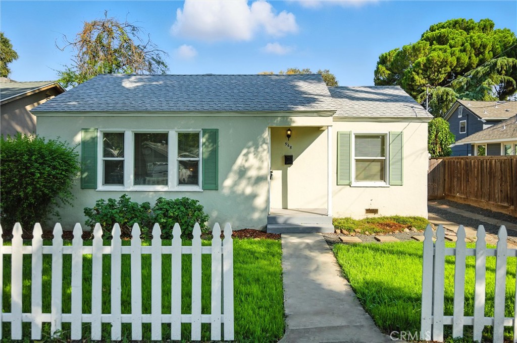 Welcome to a beautiful slice of history at 568 E 9th Avenue, a Chico charmer built in 1937 that perfectly blends vintage character with modern convenience. As you approach this delightful property, you're greeted by a classic white picket fence and a lush green lawn, inviting you to step onto the charming porch. The front shutters add a touch of whimsy and enhance the home’s curb appeal. Step inside to discover original hardwood flooring and elegant coved ceilings that resonate with character and warmth. The dining room, with its arched entry, is perfect for gatherings and showcases the home’s historic charm. A spacious kitchen featuring crisp white cabinets and dark hardware, provides an appealing contrast that adds to the home’s charm. Enjoy a lovely view of the backyard while preparing meals, where great natural lighting fills the space. The bathroom features a new vanity while maintaining its classic feel through tasteful wainscoting. The fully fenced rear yard offers a quaint patio with privacy and ample space for entertaining and gardening. Don’t miss the glorious fruit tree- the peaches are to die for! The detached one-car garage, converted into storage, provides flexibility for all your needs. Perfectly situated, #568 is just a short distance from Enloe Hospital, Bidwell Park, and the vibrant downtown Chico scene. Enjoy the convenience of neighborhood amenities, dining, and recreation right at your fingertips. Hurry! Schedule a viewing today!