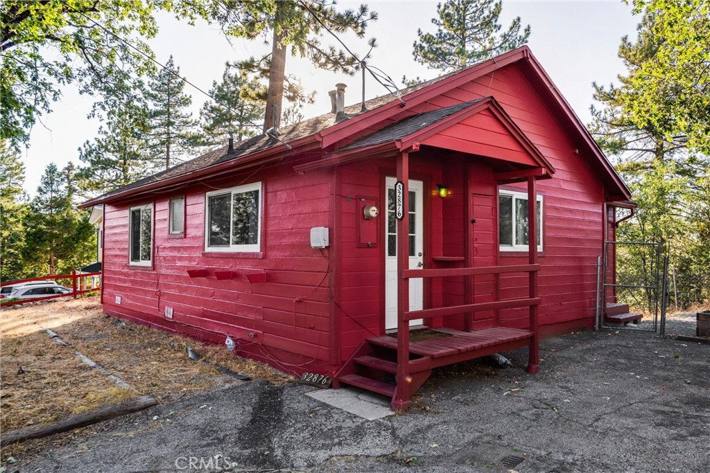 This charming and distinctive red 2-bedroom, 1-bathroom cabin represents careful stewardship rather than mere ownership. Nestled among towering pines with gorgeous mountain views, located in the San Bernardino Mountains. With easy access to outdoor recreation: under 20 minutes to Lake Arrowhead, and 30 minutes to Big Bear Lake and skiing, this home offers both immediate comfort and easy access to great outdoor adventure.
Every system has been methodically addressed: updated wiring with proper junction boxes and licensed installation, new water main connections with pressure regulation, and comprehensive safety upgrades including smoke and CO detectors. The cute kitchen showcases intentional design choices—tuxedo-style painted cabinets with open upper storage, new tiled backsplash, and new appliances including garbage disposal and oven.
The bathroom renovation features custom tilework with star-pattern flooring, a blue vanity, new faucet and pipes, plus updated ventilation. Both bedrooms include new ceiling fans, while the front bedroom offers flexible office potential. New solid core interior doors with updated hardware enhance privacy throughout the home.
Beyond aesthetics, this property prioritizes function: radiant barrier insulation in the attic, new water heater, updated HVAC servicing, anti-bird strike window treatments, and privacy stickers on neighbor-facing windows. The enclosed porch/solarium provides additional living space with new screen door and thoughtful storage solutions.
The extensive improvement list reads like a manual for responsible stewardship - each upgrade addressing long-term livability rather to make this a home.
A rare find where space has been truly inhabited rather than merely occupied.