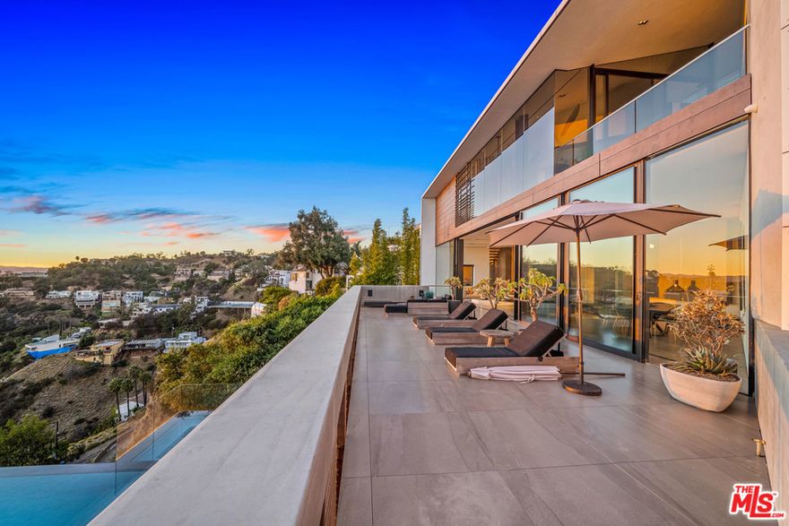 Floating above the helicopters themselves with some of the best views in the city, this architecturally significant contemporary residence in the upper Hollywood Hills. Spread over three floors, this luxury build has all the modern amenities one would expect from a premium residence of this standard. Custom details from the entry to the exterior, interior lift, Gaggenau appliances, fully automated music, alarm, blind and pool systems. Incredible design, numerous game and media rooms, all culminating in making this the ultimate celebrity enclave. Beyond the insane skyline views from every suite in the house, the 30' infinity pool and hot tub, which overlooks one of the best cityscape views in Los Angeles, the house has two large entertaining decks, decked with Italian porcelain, fire-pits and private seating areas to enjoy.