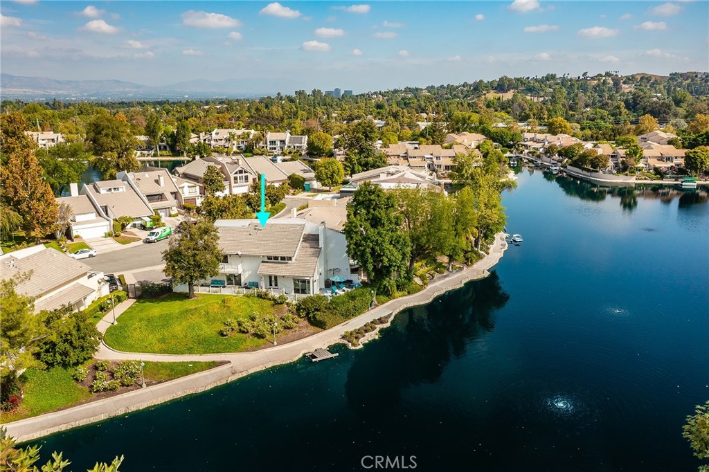 Breathtakingly beautiful 2 bedroom + loft Calabasas lakefront oasis with private boat dock situated on arguably the best view lot on the entire lake! With no neighbor to the right, the property boasts panoramic views of the lake’s largest main bay & Calabasas park where daily hillside sunsets create a magical backdrop to the sensational vistas. Located on a quiet cul-de-sac, this privately gated residence is a sanctuary of peace & serenity. Upon entering, a sweeping paver stone patio leads to a large backyard deck perfect for outdoor entertaining & enjoying the sensational views. Step through the double door entry to find highly remodeled interiors with real hardwood floors & picture windows throughout that overlook the lake & bask the home with natural light. The spacious living room features 2-story ceilings, fireplace, built-in storage shelving, & two sets of sliding glass doors that open to the yard. A separate elevated formal dining room separated by new sleek glass railings overlooks the living room & has direct kitchen access. The remodeled kitchen boasts quartz counters, stainless Sub-Zero appliances, sea glass backsplash, breakfast bar seating with pendant lighting, & pantry space. Enjoy morning coffee with lake views in the separate breakfast nook with sliding glass door that opens to the patio. The first level also features a guest powder bathroom & direct access to the 2-car finished garage with EV charging & built-in storage. Upstairs there are two bedrooms plus a large loft perfect for office or den with high vaulted ceilings & balcony overlooking the lake. The primary suite has soaring vaulted ceilings, picture windows that overlook the lake, large walk-in closet with built-ins plus separate wardrobe and shoe closets, & private newly remodeled bathroom with large vanity, quartz counters, walk-in shower, & separate built-in linen storage. A second bedroom suite opens to an oversized front balcony deck & has access to a private bathroom with tub & shower. The property also comes with access to the lake’s walking trail where you can stroll around the entire lake. Conveniently located adjacent to dining & shopping at the Calabasas Commons, Old Town Calabasas with a weekly farmer’s market, the Tennis & Swim Center, great local markets including Bristol Farms/Trader Joe’s/Gelson’s, easy access to the beach via Mulholland & Topanga Canyon, & zoned for highly rated Las Virgenes Schools. A truly remarkable offering that rarely hits the market.