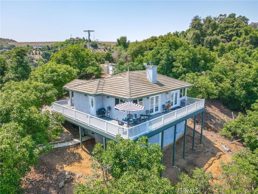 VIEWS + INCOME POTENTIAL + POSSIBLE MULTIPLE LOT SPLIT! Perched atop 22.68 acres of producing Hass avocado trees (~1,250!), this charming 1BR/1BA 908 sqft cottage offers panoramic mountain and grove views from every window. Built in 2006, the home features a full kitchen, spacious living/dining area, spa-style bath, dual-sided fireplace, and a stunning wraparound deck rebuilt in 2022. Bonus: an unfinished basement with plumbing and electrical—perfect for expanding or creating rental income. Property includes a buildable pad ideal for an ADU, workshop, or garage. Gated entry, underground PVC irrigation, 2” ag water meter, and recent upgrades (2024-2025 appliances, tankless water heater). Land may qualify for a future lot split, currently Zoned AG A70 with 2 acre parcel minimum!! -Property has multiple entrance points(three access points off Puerto del Mundo and one Easement from bottom off tecalote and green street). —buyer to verify. Endless options: STR, custom estate, boutique farm, or multi-home potential just minutes from town. GROVE PRODUCTION UPON REQUEST