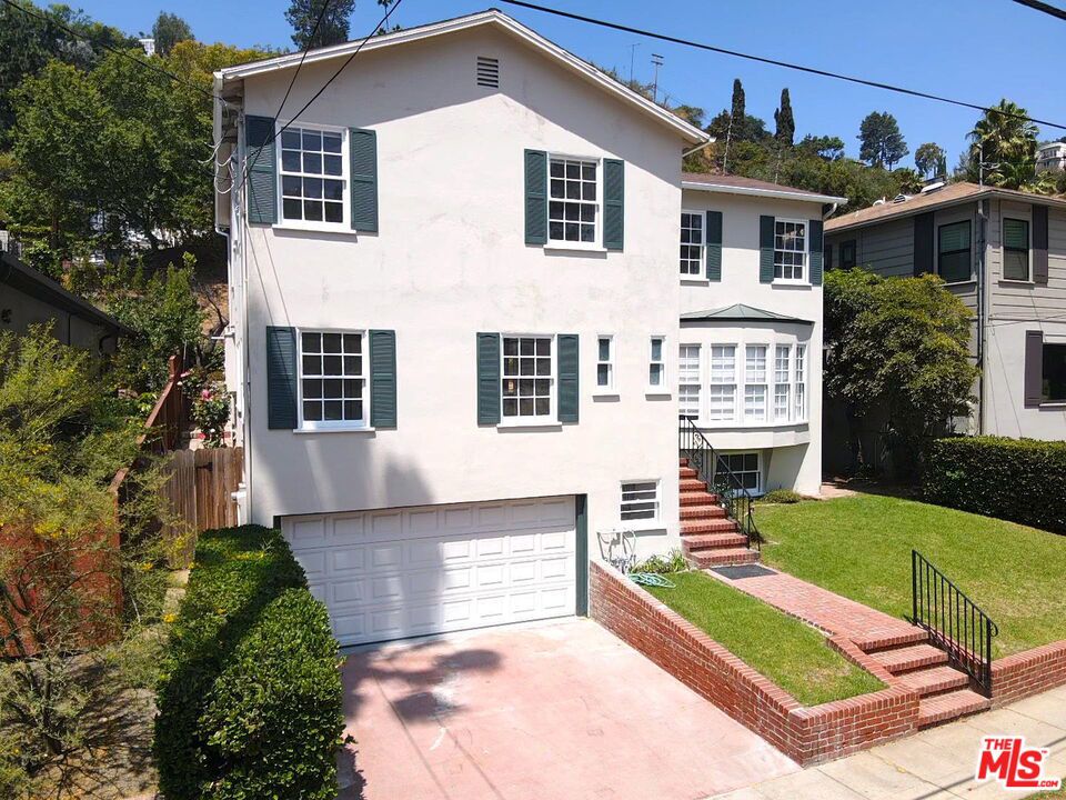 Historical home in Bronson Canyon, a Hollywood Hills Gem. Perched in the iconic Hollywood Hills, this stunning 1946 home offers a rare opportunity to rent a piece of architectural history. Blending classic California charm with modern updates, this residence caters to both sophisticated entertaining and serene, private living. A glimpse into the past, with modern comforts. Step inside to discover interiors brimming with vintage character, including rich wood floors, graceful staircase adorned with rod iron, and elegant den with rich wood paneled walls and ceiling. The updated chef's kitchen features a high-grade stove and effortlessly flows into the light filled dining room. Upstairs are the 3 main bedrooms and smaller room that makes for an excellent office or babies room. A guest bedroom or nanny's room is located on the first level at the rear of the home with access to the kitchen and a private bath. The home has lovely exteriors. Exit to the patio and yard through a set of French doors. An outdoor oasis with a multi-level design; grass lawn set above the paved patio, and a custom view deck provide a perfect setting for al fresco dining and relaxation while offering treetop views of the surrounding neighborhood and the Griffith Park beyond. Adding to the versatility of this remarkable property is a full basement, ideal for a home creative studio, guest suite or just added storage. There is even a speak-easy! Experience the allure of Old Hollywood intertwined with modern luxury in this enchanting Hollywood Hills treasure.