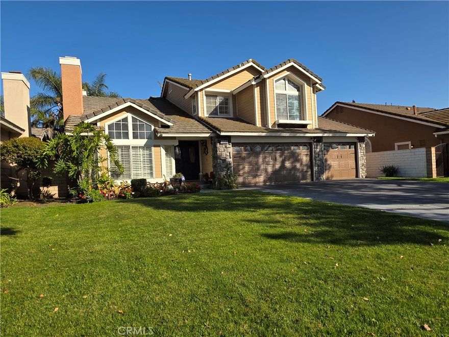 Welcome to this beautiful, well-maintained home with NO HOA and a very low property tax. The neighborhood street is lined with mature trees, and this property has strong curb appeal, with a stone facade and a wide driveway for a 3-car garage. You will be wowed as you enter through the front double glass door, with lovely wood flooring throughout, and greeted by a high cathedral ceiling. On the left is a formal living room with a gas fireplace and a raised hearth, perfect for entertaining. You will not miss the beauty of the structural design of the ceiling, which connects the high cathedral ceiling to an elegant dining room chandelier. The hardwood stairs on the right are as sleek as the rest of the house. Walk toward the hallway, and you will see a separate family room on the left with a second gas-burning fireplace adorned with glass beads, open to the kitchen area. The kitchen has a wide garden window with plantation shutters that are installed throughout the house. The kitchen was upgraded with granite countertops, a stainless steel countertop stove top fitted with a commercial-grade ducted range hood for cooking enthusiasts, and a flush wall-mounted oven/microwave. The family room sliding door opens to the patio, which features wood lattice, a built-in barbecue island, and a pool and jacuzzi. What a wonderful place to gather with friends and relatives year-round. The backyard gas fire pit table, potted plants, pool fence, and pool cover are all included. There is a bedroom and a full bath downstairs. The master bedroom is spacious, overlooking the pool from the window, and features an upgraded walk-in shower with large marble tiles. The tub is lined with a mosaic backsplash under a skylight, and on the right side is a generously sized walk-in closet with built-in cabinets. The house is loaded with built-in cabinets throughout the bedrooms, kitchen, and laundry room. The fridge and TV in the master bedroom are also included. Did I mention that the no-subscription security cameras and Tesla Level 2 charger are included as well? All you need is to bring your Tesla car :) This is a truly move-in-ready home in a sought-after school district, close to Freeways 10 & 57, shopping, and parks.