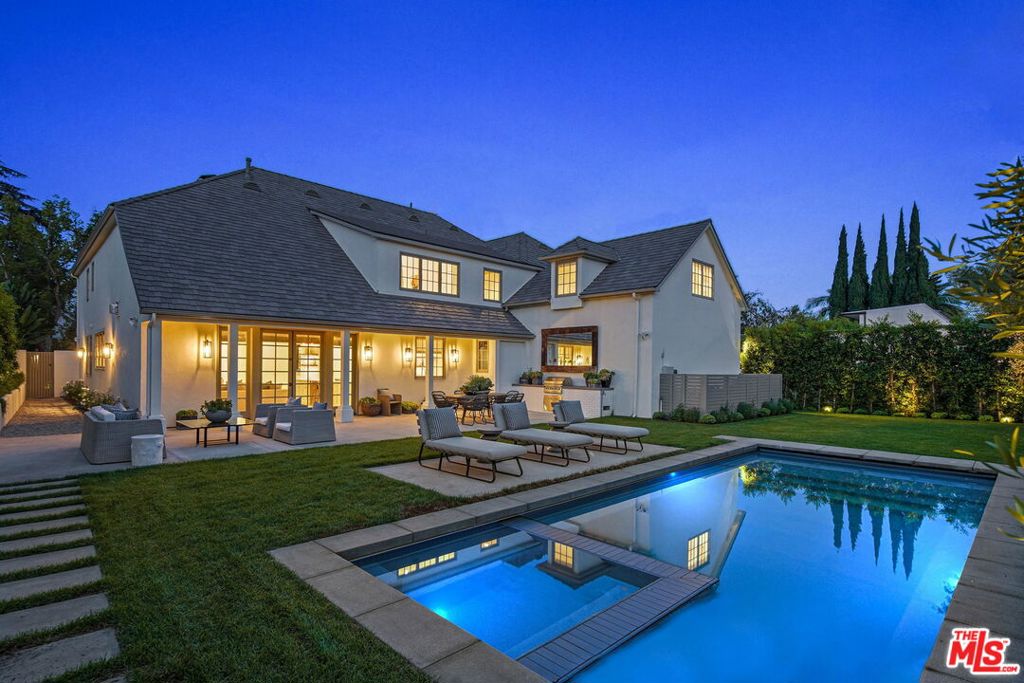 An exquisitely renovated masterpiece on the most coveted street in Beverly Hills, this 6,000+ square foot estate leaves nothing to be desired. A chef's kitchen adorned with Calacatta Gold marble opens to a family room of soaring wood accented ceilings, fireplace, casual dining area and breakfast bar all overlooking a lush green backyard with a brand new pool, hot tub and barbecue area surrounding by mature privacy hedging. Steps from the kitchen is an enormous formal dining and seating area designed for entertaining. A sun filled owner's suite features wood beamed ceilings, an impressive walk-in-close and stand alone Waterworks bathtub. 5 additional en suite bedrooms, a dedicated gym, office, separate laundry room, attached garage, new roof, electrical, plumbing, HVAC, Sonos and Lutron home automation system, water and air filtration system and tankless water heaters are all part of this recent comprehensive owner's renovation.