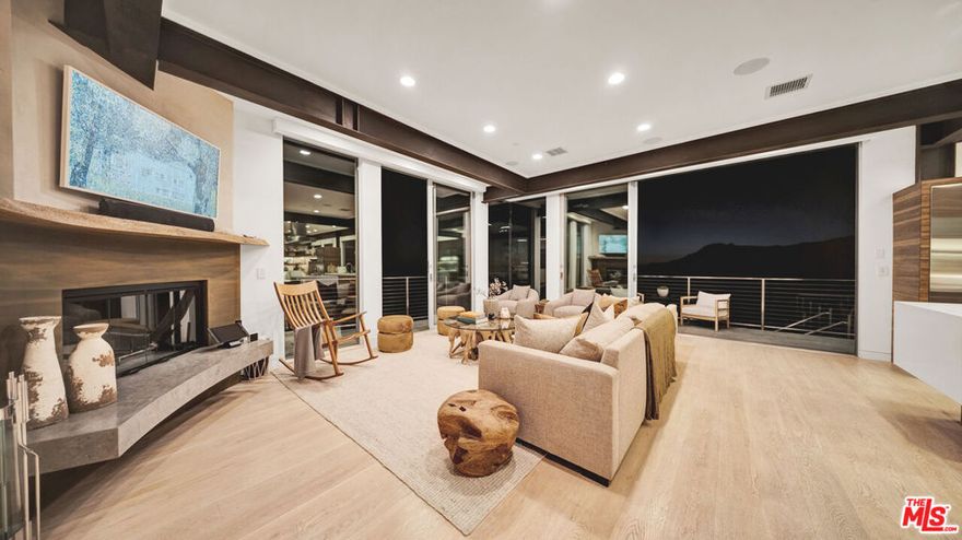 Experience one of Topanga's most captivating ocean-view estates, a modern architectural retreat surrounded by 2.4 acres of natural beauty. Set behind gates above Malibu's coastline, this residence captures sweeping vistas of the Pacific, rolling hills, and breathtaking sunsets that define coastal California living.Every detail was thoughtfully considered, blending steel, glass, and concrete with warm natural finishes to create a balanced, contemporary design. The home is equipped with solar power, backup energy systems, whole-home water filtration, and an upgraded Savant home automation platform that controls lighting, shades, sound, and climate throughout. A newly installed camera system enhances both security and convenience, and an electric vehicle charger adds everyday practicality.A serene water feature welcomes you at the entry, setting the tone for the tranquil atmosphere that flows throughout. Inside, walls of glass open to expansive patios, filling the interiors with natural light and cool ocean breezes. The living room centers around one of three fireplaces and connects effortlessly to the dining area and the chef's kitchen. The kitchen is an inspired space with professional-grade Wolf and Sub-Zero appliances, double ovens, multiple sinks, and dual Viking dishwashers, all curated for both daily living and entertaining.The ocean-view primary suite feels like a private retreat, with floor-to-ceiling glass, a spa-style bath with steam shower, and a spacious balcony perfect for morning coffee or sunset views. Two additional guest suites complete the main level, while the lower level features a media lounge with wet bar and an additional en suite bedroom ideal for a home office or gym.For cat lovers, the property includes a custom-built catio that blends seamlessly with the home's architecture, offering a safe outdoor space for pets to enjoy the fresh air.Designed for both connection and escape, this property offers privacy and scale while remaining only minutes from the beach via scenic Tuna Canyon Road. With parking for up to 10 cars, an electric vehicle charger, nearby hiking and biking trails, and cinematic ocean views from nearly every room, it's a rare opportunity to experience design, nature, and coastal living in perfect harmony.