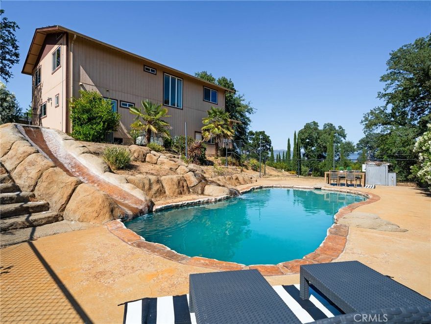 Rare find! Spacious home plus a second buildable lotperfect for a future guest house, multigenerational living, or investment opportunity. Tucked behind mature trees, this turnkey property features vaulted ceilings, an open floor plan, and a chef's kitchen with stainless steel double oven, large island, and walk-in pantry. The main-level primary suite includes a jetted soaking tub and walk-in closet. Upstairs offers three spacious bedrooms, a full bathroom, a large family room with walk-in closet, and a laundry chute. Step into your private backyard retreat with a Gunite pool, slide, waterfall, and hot tub. Extras include: paid solar, dual-zone HVAC, whole house fan, city water plus private well, septic, leased propane, auto irrigation, and a full security system. The property is fully fenced with a 6' black powder-coated fence and custom gates, with a finished 2-car garage and Trex-deck front porch with recessed lighting.