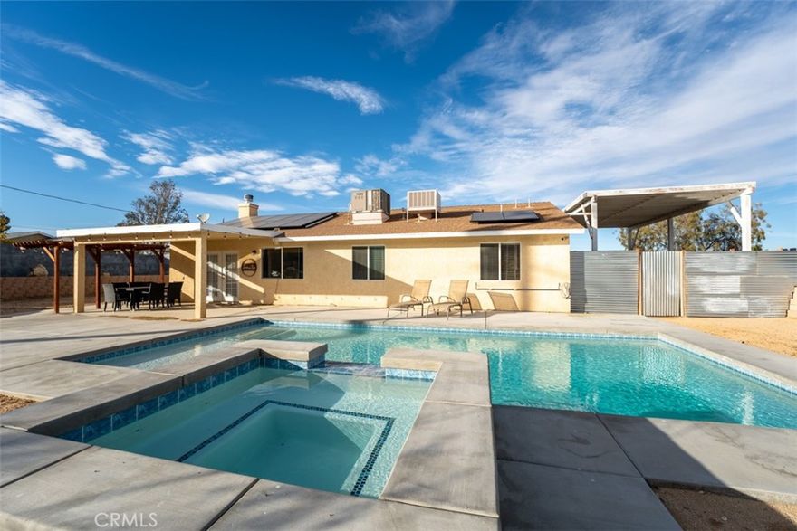 Welcome to 60205 Latham Trail, a stunning desert retreat nestled in the desirable Upper Friendly Hills neighborhood of Joshua Tree. This beautifully designed single-family residence offers the perfect blend of modern comfort and serene desert charm. Sitting on a spacious lot, this home boasts breathtaking mountain and sunset views, creating a peaceful escape from the everyday hustle. Inside, you'll find an inviting open-concept layout with high ceilings, abundant natural light, and stylish finishes throughout. The kitchen is equipped with modern appliances, sleek countertops, and ample storage, making it perfect for cooking and entertaining. The primary suite provides a tranquil oasis with a spa-like bathroom and direct outdoor access to enjoy the fresh desert air. Step outside to your private backyard retreat, where you can relax under the stars, soak in the sun, or entertain guests with the stunning desert landscape as your backdrop. Conveniently located just minutes from Joshua Tree National Park, local dining, and shopping, this home is ideal for a full-time residence, vacation getaway, or investment opportunity.