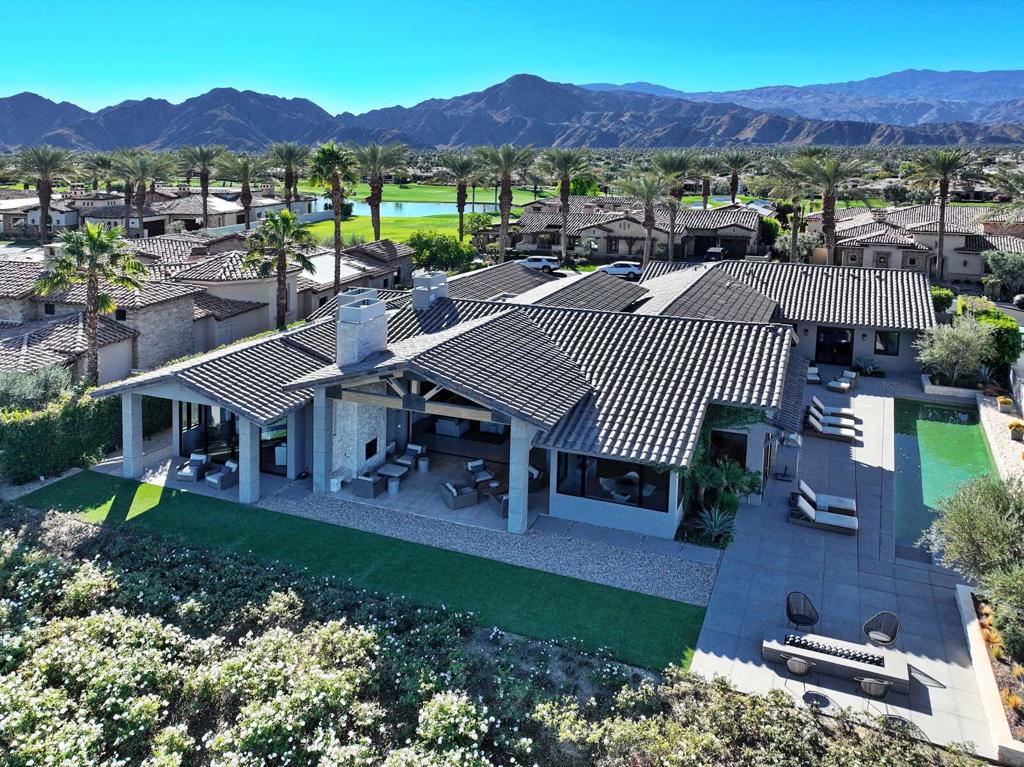 Situated on a lush fairway of Toscana Country Club's South Course, this exquisite rustic contemporary estate offers stunning views of the Jack Nicklaus-designed golf course and surrounding landscape. Featuring soaring 22-foot ceilings with exposed beams, limestone porcelain floors from Italy, and hardwood floors throughout, this home exudes elegance. A private, stand-alone office provides a quiet space for work or relaxation, offering scenic views of the golf course.The Chef's Kitchen boasts a Wolf 60'' stove, Sub-Zero appliances, Meile dishwasher, and a wine refrigerator, complemented by walnut custom cabinetry and marble counters. The dramatic great room with retractable glass doors opens to a resort-style backyard, complete with a 45-foot lap pool, firepit with seating, and a covered patio with a fireplace for dining and lounging.The master retreat features a fireplace, marble walk-in shower, heated floors, and direct access to the outdoor patio. An attached guesthouse with kitchenette and separate entrance adds privacy, for guests staying in either of its two bedrooms. Additional amenities include garage space for four cars, a circular driveway, Control4 home automation, and custom backyard lighting.With a custom step-down bar area, a 15-foot glass entry door, and luxurious finishes, this home offers the ultimate in sophisticated desert living, blending style, comfort, and elegance in every detail.