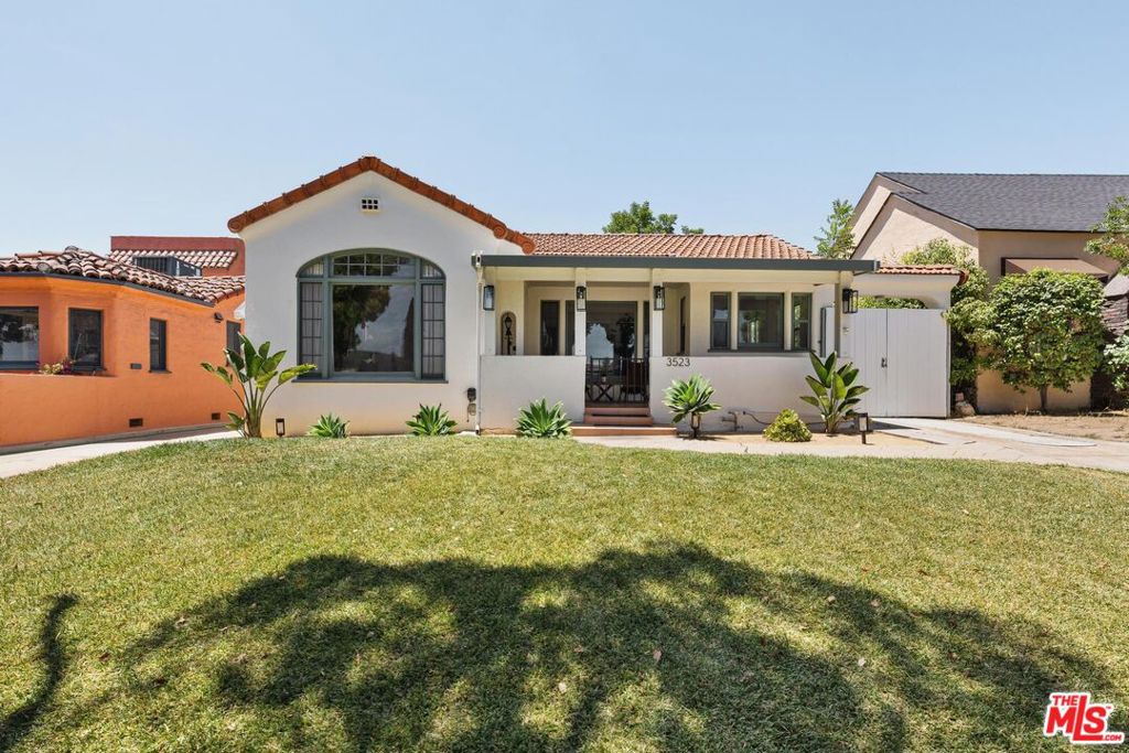 Discover the perfect blend of historic charm and modern convenience in this beautifully updated 1926 Spanish gem. Nestled on a tranquil, tree-lined street, this exquisite home offers the best of Eastside living. The main house welcomes you with its original, gracefully curved high ceilings in the living room, creating a sense of timeless elegance. It includes two spacious bedrooms, a well-appointed bathroom, and an enclosed porch that serves as a versatile bonus room. Step outside to find a delightful 422 sq. ft. guest house, complete with its own kitchen and bathroom, offering privacy and flexibility for guests or extended family. Additionally, a separate flex office space is surrounded by lush, mature fruit trees and fragrant jasmine bushes, creating a serene oasis for work or relaxation. With ample driveway and street parking, this home provides both convenience and a warm, inviting atmosphere. Experience the pinnacle of Eastside living in this unique property right on the Alhambra / El Sereno border.