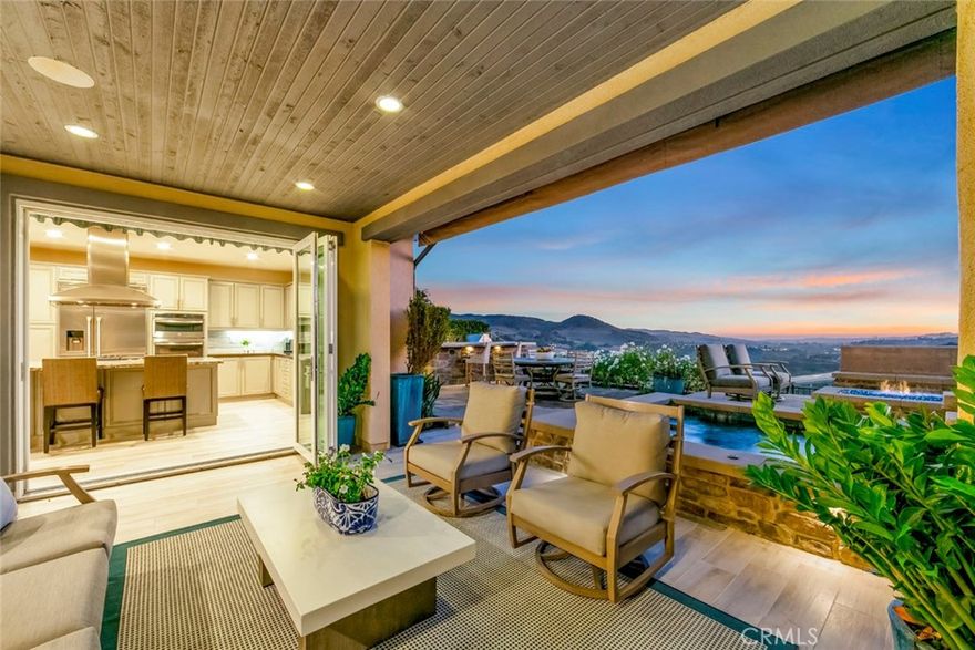 Welcome to one of Rancho Mission Viejo’s most remarkable view homes! An architectural masterpiece in the exclusive Ventana enclave in the award-winning community in Rancho Mission Viejo. This residence is designed for both grand entertaining and everyday luxury. The backyard is a private retreat featuring a custom-designed jacuzzi with a rare standing zone for a full-body hydro massage, a tranquil waterfall feature, gas fire pit, built-in BBQ with full appliances, and generous gathering space. All set against sweeping views and refreshing ocean breezes. The great room impresses with a 16-foot sliding glass door that seamlessly connects to the covered California Room, complete with fireplace, designer ceiling paneling, and a motorized retractable awning extending 16 feet for instant shade at the touch of a button. Inside, the kitchen is a chef’s dream, a built-in refrigerator, wine refrigerator, abundant cabinetry, and an oversized island invite both creativity and connection. The main level includes a full bedroom and bath, while upstairs offers a spacious loft and three additional bedrooms. The primary suite is a true sanctuary with panoramic views and a private balcony adorned with custom ceiling paneling. Additional premier features include epoxy-coated garage flooring with built-in cabinets, plantation shutters, custom closets, surround sound, and thoughtfully designed built-ins throughout. This home delivers the perfect balance of architectural design, modern comfort, and resort-style living, a rare find in one of Rancho Mission Viejo’s most coveted enclaves. Exclusive to Rancho Mission Viejo residents are all amenities in the Villages of Sendero, Esencia, Rienda and future Villages. There are community amenities for all from breath-taking resort-style pools and spas, Esencia school K-8, community farms, fitness centers, guest house, putting green, bocce ball courts, tennis and pickle ball courts, playgrounds, coffee shop, fire pits, an arcade and so much more!