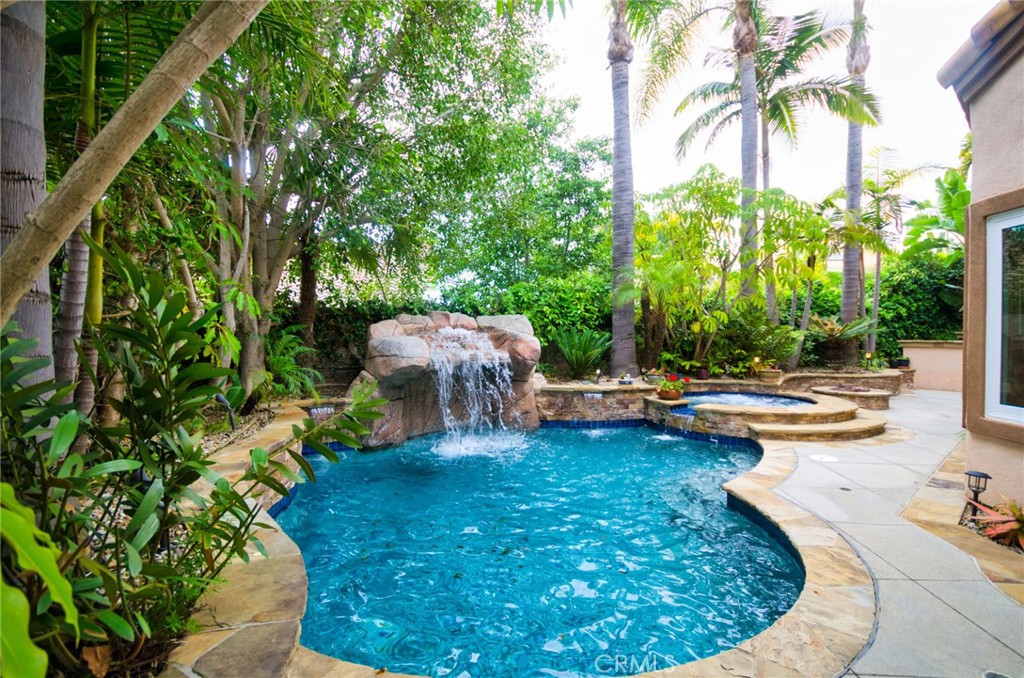 *A Tranquil Suburban Oasis*
Freshly painted and move-in ready, this beautifully crafted four-bedroom home with a spacious loft offers the perfect blend of comfort, style, and serenity. Outfitted with 32 fully paid-off solar panels, it delivers modern energy efficiency without compromising on luxury.
Set in a peaceful neighborhood surrounded by lush trees, the property boasts a tropical garden designed for relaxation, complete with a soothing waterfall and a sparkling saltwater pool, creating a private resort-style retreat. Inside, rich hardwood floors and travertine tile accents add warmth and elegance to the main living areas.
The versatile loft provides space for a home office, playroom, or creative studio, adapting effortlessly to your lifestyle. From quiet moments in the garden to cozy evenings indoors, this home offers a rare opportunity to enjoy nature and elegance in perfect harmony.