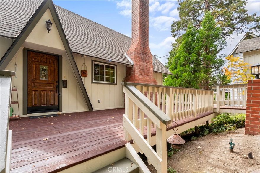 MID-CENTURY GEM WITH LAKE RIGHTS IN PRESTIGIOUS GRASS VALLEY NEIGHBORHOOD.  Join one of the premier residential areas in Lake Arrowhead with LAKE RIGHTS and its own Grass Valley Lake.  This home blends modern updates with classic mountain charm, offering privacy, views, and a lifestyle that’s both tranquil and connected.  
PROPERTY HIGHLIGHTS: This meticulously renovated cabin w/2 BD, 2 Full BA on two levels and THREE SCENIC DECKS (front, back and lower level).  The cozy home’s entrance is set back well off the street.  Street-LEVEL garage entry plus lighted concrete steps lead to a custom front door with vintage glass and A-Frame overhang.  
OPEN FLOOR PLAN: Step inside to an inviting open-concept layout featuring a foyer, bright kitchen w/island, dining nook and expansive living room.   Soaring cathedral ceilings in wide plank caramel pine pair beautifully with ebony wood-framed windows and doors, while a whitewashed brick fireplace anchors the large living area with timeless elegance.  Sliders open to a spacious deck for morning coffee or evening entertaining.   Above the main living area, a sun-drenched loft offers flexible space for a home office, reading retreat or guest sleeping.  
LOWER-LEVEL COMFORT:  Two generously sized bedrooms with large windows and custom cabinetry are downstairs.  One BD has wood wainscotting accents and is adjacent to the first large, gleaming full bath.  The ensuite bedroom leads to deck with entrance to this level for easy backyard access. 
BONUS SPACES & OUTDOOR LIVING:   A finished workroom/office with a large window is just steps from the garage. A brick-paved side yard is ideal for entertaining and future firepit installation.  Expansive, terraced backyard is complete with an elaborate swing set, children’s playhouse, and a rustic, meditation bench among mature trees. Near the country club golf course and “Arrowhead Ridge” trailhead.