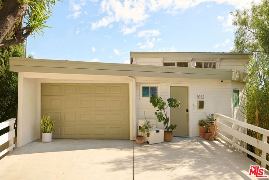 Perched in the foothills of Mount Washington, this striking 2 bedroom, 2 bathroom mid-century modern hillside home offers high design, city views, and a dreamy, perfectly landscaped yard, a true tranquil refuge. The home offers a newly designed and renovated kitchen and bathrooms, featuring chic matte tile, Eny Lee Parker light fixtures, and Phylrich showerhead, faucet, and fixtures. The expertly curated, expansive backyard offers a series of intimate vignettes for relaxation and entertaining, including built-in seating, an outdoor dining area, a dipping tub under a canopy of mature eucalyptus trees, olive trees, and an abundance of fruit trees. The main level opens to an airy, open-concept layout defined by vaulted wood-beamed ceilings, clerestory windows, and a dramatic wall of glass. The freshly reimagined kitchen with its custom cabinetry, quartz countertops, and designer lighting anchors the living space and provides a dining area flanked by floor-to-ceiling windows. An upper-level patio extends off the kitchen, allowing a serene space to soak in the views with morning coffee. A fully renovated main floor bathroom features refined tilework and sleek fixtures, completing a level that feels both warm and sophisticated. The lower level features two spacious bedrooms, each with ample closet space, and a charming outdoor patio located off the primary bedroom. The shared bathroom has generous proportions, modern finishes, including a Kelly Wearstler light fixture, stone countertop, and Kohler hardware. Step outside into a garden that feels like its own hidden world, a lush, layered landscape filled with mature fruit trees, towering eucalyptus and acacia, and meandering passion fruit and star jasmine vines that drape with effortless beauty. Multiple seating areas are tucked throughout, inviting quiet mornings with coffee or long afternoons beneath the trees. A flagstone pathway winds through the designer-curated California and Australian native greenery, leading to a 10-foot filtered cowboy tub set perfectly for stargazing nights, while expansive decks and shaded nooks offer space to dine, gather, or simply breathe it all in. It's a rare and romantic outdoor sanctuary alive with texture, scent, and soul. This Mt. Washington residence offers an elevated lifestyle in one of Northeast LA's most sought-after enclaves. Enjoy easy access to the best of the vibrant Eastside culinary scene, including Barra Santos, Wife & Somm, Dunsmor, Little Ripper, and The Grant. Begin the day with coffee from Loquat before exploring nearby Moon Canyon Park or the trails of Elyria Canyon. A home of striking form and function, it embodies the ideal fusion of modern design, California hillside living, and outdoor splendor.