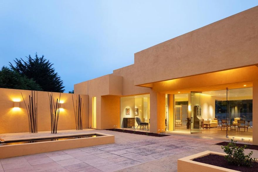 Tucked into a private 1.8 acre parcel in the heart of world-famous Pebble Beach sits a wonder of modern design. Conceived and drawn by the owner, the minimal cubist-style home enjoys a private setting surrounded by trees and flush with natural light. The 2,540+ square foot home has an open floor plan surrounded by nine and a half foot glass walls that look out onto a spacious interior courtyard and exterior gardens with reflecting pools thoughtfully positioned to provide a calming, reverent ambiance for both the interior and exterior spaces. French limestone floors and smooth Venetian plaster walls exemplify the simple elegance envisioned by the owner.  While currently a one-bedroom two bathroom configuration, there is space to easily create additional bedroom suites. Other highlights include radiant heated floors throughout, an open spa-like primary bath, a well-appointed garage, hidden rooftop solar panels, and the striking sculpture at the rear of the property that is seen from the moment you walk through the front entrance. With all the amenities of The Lodge and resort just around the corner, this completely unique Pebble Beach residence is ready to welcome the sophisticated style of its new owner.