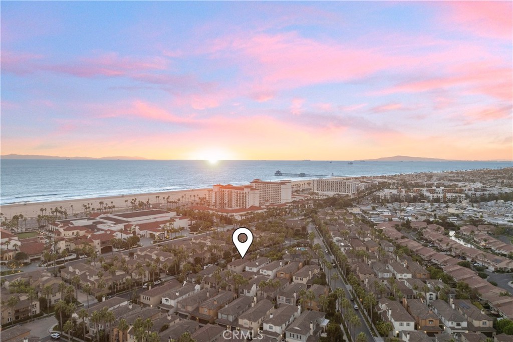 Experience resort-inspired coastal living in one of Huntington Beach’s most prestigious gated communities — The Waterfront. This exquisite 4-bedroom, 3.5-bath residence offers the community’s largest floor plan and an unmatched location just across from the ocean, moments from world-class dining, surf breaks, and resort destinations. Designed with sophistication and comfort in mind, the home’s lower level features rich oak floors leading to a chef’s kitchen appointed with a DCS 6-burner cooktop and oven, SubZero refrigerator, soft-close cabinetry, quartz countertops, and an impressive Brazilian brushed granite island. The open layout flows seamlessly into the living and dining areas, creating an inviting atmosphere for both everyday living and entertaining. A versatile downstairs bedroom has been thoughtfully transformed into a soundproof theater or music studio, complete with a stage and projector screen—ideal for immersive movie nights or professional-quality music sessions. Upstairs, two spacious guest suites include walk-in closets, one with a private en suite, while the primary suite impresses with vaulted ceilings, a walk-in closet, and views of the sparkling community pool. With exclusive access to resort-style amenities and an unbeatable location just moments from the sand, this rare offering combines elegance, comfort, and the best of coastal living.