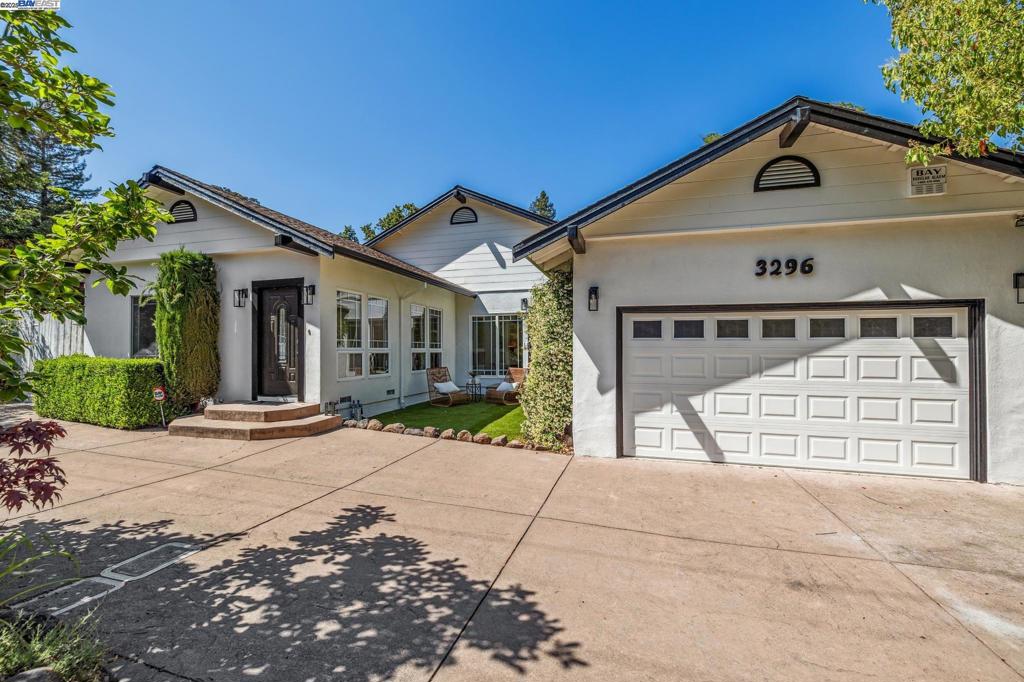 A gracious entrance and circular driveway offer an elegant welcome to this versatile single-level mid-century ranch in Lafayette’s coveted Burton Valley. Inside, beautifully updated spaces include four bedrooms and a bright, open layout. The main living area flows to a side patio off the kitchen, while the expansive primary suite offers large windows, sliding doors to the backyard, and a luxe ensuite with soaking tub, dual sinks, stall shower, and laundry. A bonus room off the primary makes an ideal office or sitting area. Two bedrooms share a dual-access bath, and a fourth—used as a family room—features an adjacent remodeled full bath and opens to the backyard. Don’t miss the second half of the lot over the wood bridge and creek, offering tons of upward and outward expansion potential. Fresh paint, new lighting, refreshed landscaping, and an attached 2-car garage complete the home. Enjoy suburban tranquility, top-rated schools, outdoor recreation, and easy access to shopping, dining, BART, and Hwy 24.