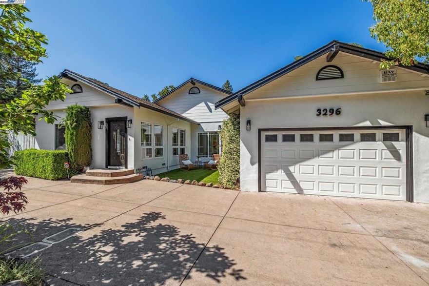 A gracious entrance and circular driveway offer an elegant welcome to this versatile single-level mid-century ranch in Lafayette’s coveted Burton Valley. Inside, beautifully updated spaces include four bedrooms and a bright, open layout. The main living area flows to a side patio off the kitchen, while the expansive primary suite offers large windows, sliding doors to the backyard, and a luxe ensuite with soaking tub, dual sinks, stall shower, and laundry. A bonus room off the primary makes an ideal office or sitting area. Two bedrooms share a dual-access bath, and a fourth—used as a family room—features an adjacent remodeled full bath and opens to the backyard. Don’t miss the second half of the lot over the wood bridge and creek, offering tons of upward and outward expansion potential. Fresh paint, new lighting, refreshed landscaping, and an attached 2-car garage complete the home. Enjoy suburban tranquility, top-rated schools, outdoor recreation, and easy access to shopping, dining, BART, and Hwy 24.