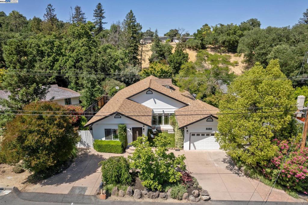 A gracious entrance and circular driveway offer an elegant welcome to this versatile single-level mid-century ranch in Lafayette’s coveted Burton Valley. Inside, beautifully updated spaces include four bedrooms and a bright, open layout. The main living area flows to a side patio off the kitchen, while the expansive primary suite offers large windows, sliding doors to the backyard, and a luxe ensuite with soaking tub, dual sinks, stall shower, and laundry. A bonus room off the primary makes an ideal office or sitting area. Two bedrooms share a dual-access bath, and a fourth—used as a family room—features an adjacent remodeled full bath and opens to the backyard. Don’t miss the second half of the lot over the wood bridge and creek, offering tons of upward and outward expansion potential. Fresh paint, new lighting, refreshed landscaping, and an attached 2-car garage complete the home. Enjoy suburban tranquility, top-rated schools, outdoor recreation, and easy access to shopping, dining, BART, and Hwy 24.