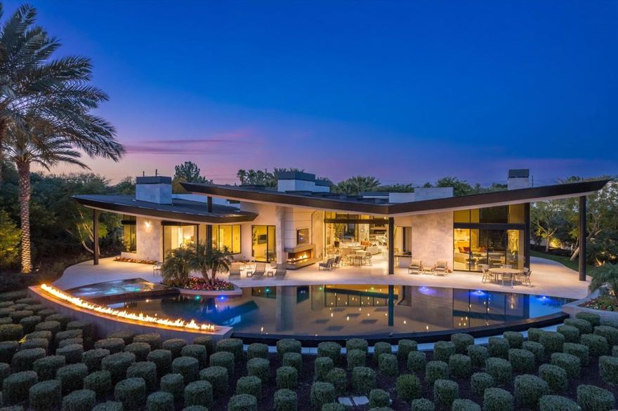 This unique trophy property nestled behind the gates of the Madison Club boasts a total of 9,974 sq ft of meticulously handcrafted quality and elegant stone finishes. This estate is situated on approx 1.5 lushly landscaped acres surrounded by an additional 1.5 acres of HOA maintained open space. The incredibly well thought out main residence of 7,677 sq ft showcases 3 beds, 3.5 baths, office and theater. A gourmet kitchen overlooks the grand family room and includes a butler's kitchen. The elegant dining room includes a glass front wine room and is graced with a stunning chandelier. The 2,297 sq ft guest home mimics the quality and perfection of the main home with its own living and dining area, kitchenette, 3 guest suites, garage and car port. The grounds also feature an indoor/outdoor bar, BBQ, infinity edge pool with yoga/tanning shelf, oversized spa along with numerous fire and tranquil water features. Impeccable design, unparalleled quality and paramount location.