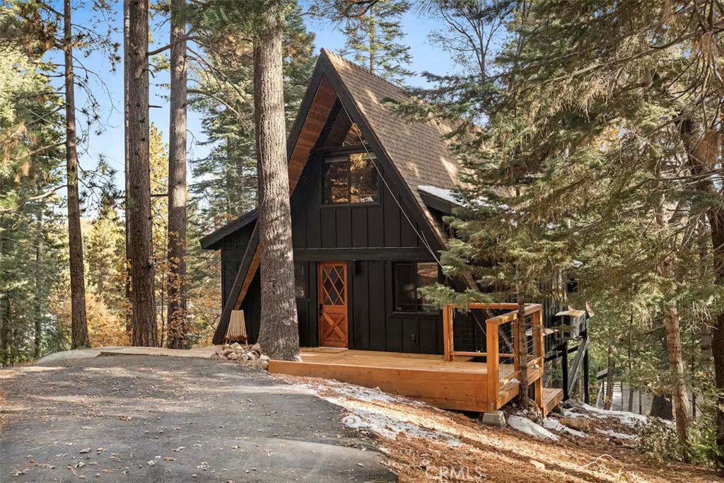 Welcome to 26664 Thunderbird Drive – a stunningly reimagined A-frame retreat nestled in the heart of Lake Arrowhead’s desirable Arrowhead Woods community. Sitting on nearly 0.4 acres of usable, forested land, this two-bedroom, one-bath cabin blends timeless mountain charm with elevated modern design and thoughtful upgrades throughout.
Step inside to soaring vaulted ceilings, a dramatic wall of windows, and an open-concept great room that’s bathed in natural light. The spacious living area is anchored by a sleek gas fireplace and flows seamlessly into a beautifully renovated kitchen featuring custom plaster countertops, ZLine retro-style appliances, and curated finishes that bring a sense of sophistication to rustic living.
The main-level bedroom offers comfort and privacy, while the upper loft acts as a flexible second bedroom, complete with a king-size bed and cozy office nook—ideal for working remotely or hosting guests. The bathroom is a true showstopper, boasting a curbless walk-in shower with handcrafted Zellige tile, radiant heated flooring, and a modern bidet.
Additional highlights include a dedicated laundry/mudroom with washer and gas/electric dryer, ductless A/C for year-round climate control, updated lighting, plumbing, and electrical systems, and ample storage throughout.
Outdoors, enjoy your morning coffee or evening wine on the large wraparound deck overlooking a lush forest of pines. The nearly level lot offers potential for expansion, garden space, or even a hot tub. The circular driveway provides generous parking—including space for RVs, trailers, or multiple cars.
This turnkey home comes with coveted Lake Arrowhead lake rights, granting access to private beaches, docks, and year-round recreation. Located just minutes from Lake Arrowhead Village, local trails, the country club, and seasonal ski resorts, this is the ideal mountain escape—perfect as a full-time residence, vacation getaway, or income-generating short-term rental.