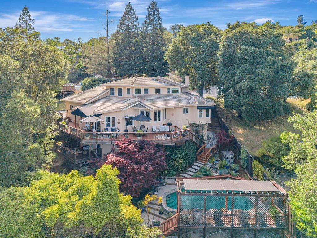 Stunning residence offers a rare blend of natural beauty & serenity. Inside, you'll find a spacious and flexible layout with a rustic stone fireplace and wood-planked ceilings, creating an inviting warmth atmosphere. The expansive indoor formal areas seamlessly flow outdoors to sprawling tiered decks with views of the city and hills. Sparkling pool and hot tub, poolside deck with fan, fire pit, and meditation spaces, ideal for entertaining, or simply enjoying the tranquility of the lush trees and waterfall. This split-level home is thoughtfully designed to accommodate a growing family or multigenerational living. The main floor includes a kitchen with gourmet appliances including a New Cafe double oven range and Bosch dishwasher, granite slab counters, living room & dining area with vaulted ceilings, main level bedroom and full bath. Upstairs, the primary suite has a full bath, soaking tub, and a walk-in closet. High quality grade Milgard windows, house attic fan, and new AC system. 5 Bedroom-3.5 Baths 3,240 living sq-ft - Lot size 11,550, Oversized 2-Car garage w/work area. Walk-in basement w/ workbench, approx 200 sq-ft. Bonus Rec Room/Den with it's own deck. In close proximity to dining, wineries, and hiking trails. Christopher High Attendance Area, Welcome Home!