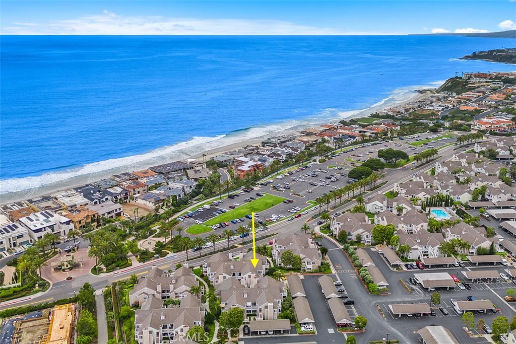 Just steps from the surf and sand at iconic Strands Beach, this beautifully updated ground-level corner unit in Dana Point offers the perfect blend of style, comfort, and location. Boasting 2 bedrooms, 2 bathrooms, and 1,022 square feet of thoughtfully designed living space, this unit resides in a front-row building and is nestled in one of the most sought-after coastal communities of Niguel Beach Terrace. Inside, you'll find a light and airy open floor plan with travertine tile floors throughout, a cozy fireplace, and large windows that flood the space with natural light. The living area flows effortlessly to a charming covered patio, creating the ideal indoor-outdoor living experience. The well-appointed kitchen features granite countertops, stainless steel appliances, and crisp white cabinetry. Both bedrooms are generously sized, with the primary suite offering its own en suite bath and access to the main patio. The secondary bedroom has its own private patio and wall to wall custom wardrobe wooden doors. Interior laundry is a rare find in this community so this unit truly has it all. Set within a well-maintained community just across the street from Strands Beach, this condo is perfect as a primary residence, vacation home, or investment opportunity. With two private outdoor patios and easy access to the best of Dana Point—including walking trails, world-class resorts, downtown shops and restaurants, and Dana Point Harbor—this is coastal living at its best.