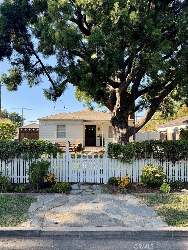 In 1939 R W Haysel built this custom home in what was known as Knob Hill. The Minimal Transitional style with white clabbered siding all around is now know as "Cottage" style today. The neighborhood is now called Park Santiago. Loaded with vintage quality and charm this home has beed upgraded with modern guts that bring peace of mind. The picket fence and roses welcome you as you walk up a flagstone walk past a mature Podocarpus tree to the brick front porch. The front yard is a wonderful spot to chat with neighbors or watch your kids play. Step inside and discover the original Oak hardwood floors and a traditional Federal style mantle in the bright living room. A good size dining room opens to a bright all new kitchen. The current owners tackled this project first first by adding a skylight and opening up walls to create a new heart of the home. Enjoy cooking and entertaining in this space with a large center island and 5 burner gas cooktop, The bar area has a second sink and wine fridge. The farm house sink and quartz counters make clean up a breeze. A small walk in pantry will keep you organized. Beyond the kitchen is a cozy Den added in 1975 by a prior owner. It leads to the back yard and garage. There are 2 bedrooms and one bath in the front of the house. A true main bedroom was added by the original owner with double closets, a private bath and a bonus side room perfect for a nursery or office. There is a new energy efficient HVAC system with all new ducting. Copper and pex plumbing. Drain line are ABS. There is a detached 2 car garage with a gated drive. The back yard is pretty simple today with lawn, a kids play area, chicken coop with chickens! 3 raised planters that are loaded with tomatoes and more. What would you do back here? Park Santiago is a vintage neighborhood with mostly custom homes and a few track streets. The northern border is flanked by Santiago Park, a beautifully renovated park with play areas, tennis, pickleball, lawn bowling, bike trails and more. The volunteer association plans fun seasonal events. Weather you are walking your dog, riding your bike down the tree lined streets or relaxing in your own yard you will enjoy this quiet spot of Orange County in the middle of everything!