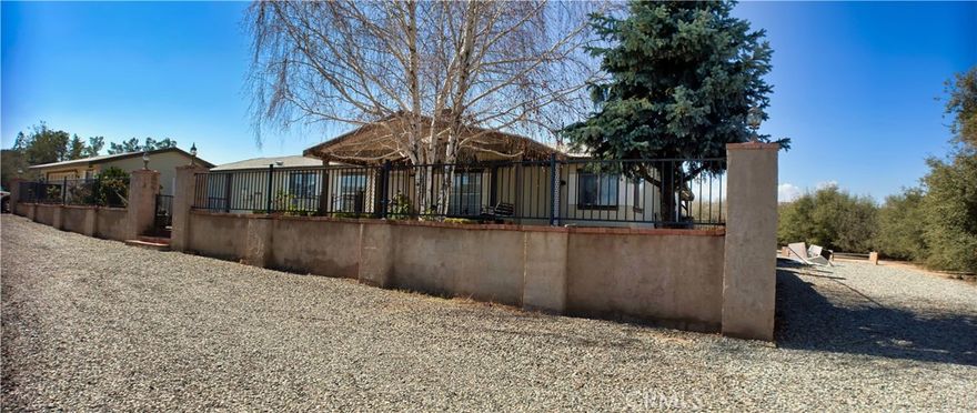 Everything you could desire for secluded living in close proximity to city, freeways and ammenities.  This property features 3 bedroom, 2 baths, formal living room, formal dining room with a fireplace situated on almost 2 acres of land.  Manufactured home on a permanent foundation also includes a 2 car attached garage and 2 storage rooms.  Relax on your front and rear covered patios and watch the sun go down and the twinkling of the stars.  The property also features a green house and an above ground pool. Relax and sleep well knowing your property is fully fenced and equipped with an electric gate.  Need RV parking, well look no further there is an RV 3 sided garage.