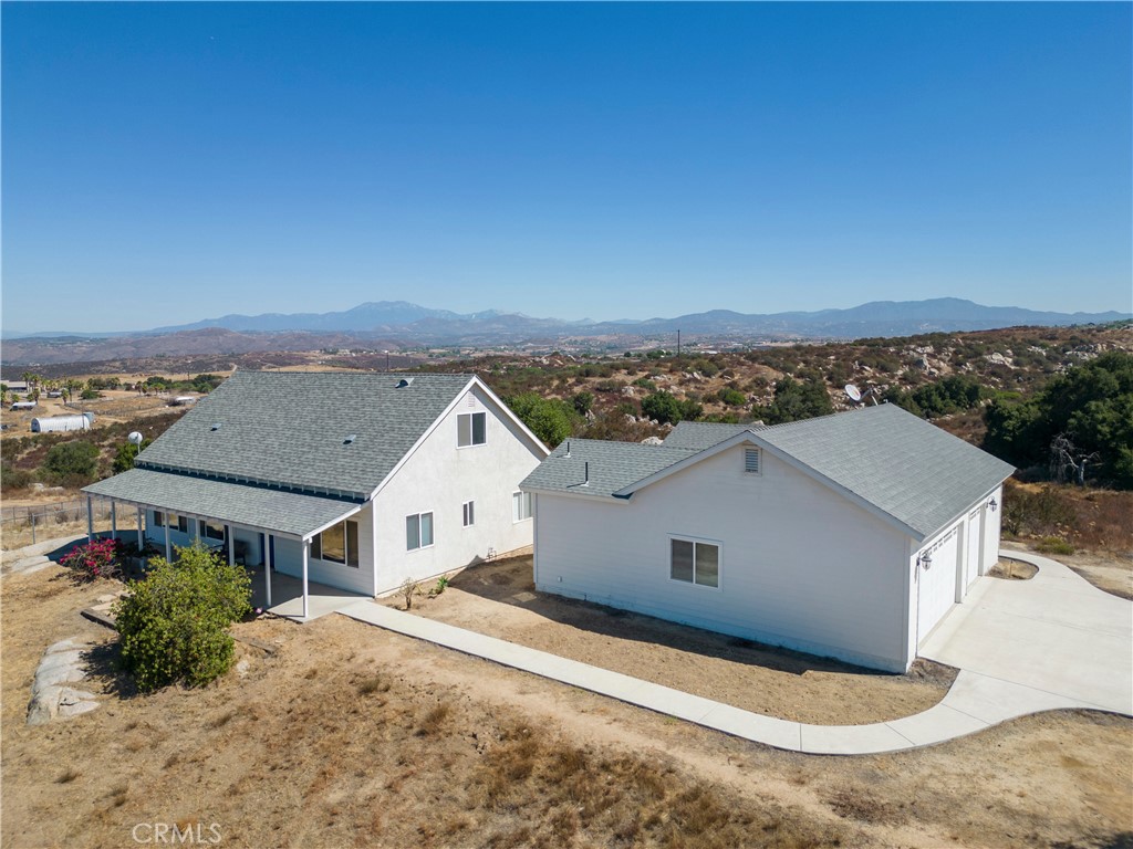 A custom home in the Temecula wine country. Property has a Main home, a detached guest house, a large detached garage-workshop, and a barn with corrals all on 10 acres of land! Located above the highly desirable Glenoaks Hills area in the heart of the Temecula wine country. Ten acres with 360 degree views of Lake Skinner and the wine country and city lights! Enter the main home into a spacious living room with a bank of windows to take in the fantastic views. Your gaze will be drawn to the spiral staircase leading to the upstairs huge 4th bedroom/office. The sunny and bright kitchen with custom cabinetry and granite counters, and large island with seating, and a pantry offers plenty of storage space. The outdoor covered patio welcomes you to relax and enjoy the view and watch the hot air balloons glide overhead. The private Guest house, Casita with its separate entrance offers an open concept floorplan with kitchenette and full bath. The combined living area for the home and casita totals over 2500 sqft! A detached garage has been drywalled and the workshop floor sealed with epoxy, perfect for a pool table or hobby game room, leaving the remaining bay space available for parking, and access to the attached laundry room. Additionally, there is an office room with a private entrance attached to the garage. The horse facilities include a 36X48 barn with in and out stalls with welded wire panels, with large open span area for tractor parking, tack or hay storage. There are additional turnouts with covered corrals. The twenty solar panels are seller owned. There are two permitted wells that are not in use as property is connected to municipal water source. Water bond has been paid in full. Low taxes! Property split potential.
