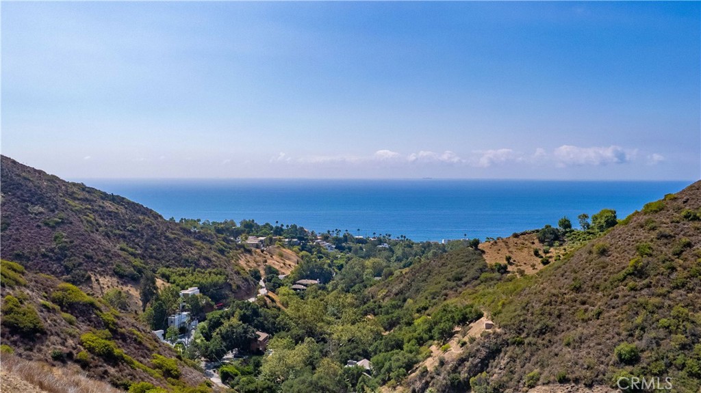 Discover a rare gem in Malibu’s breathtaking landscape! This stunning 8-acre private lot, just a mile from the iconic shoreline, boasts jaw-dropping ocean views that inspire dreams. Previously approved plans envision a sophisticated 4,350 sq. ft. single-story masterpiece designed to capture every shimmering wave, yet the possibilities are endless. The expansive, flat home-site pad invites you to create an even grander estate or dual residences. Remnants of a former home offer solid concrete footings, perfect for a basement or wine cellar, adding character to your vision. A gentle seasonal stream weaves through lush, mature trees and vibrant landscaping, creating a serene oasis. As a delightful bonus, a charming small home and storage space provide convenience during construction or a cozy retreat. Don’t miss this once-in-a-lifetime chance to craft your legacy in the heart of Malibu’s majestic beauty—act fast!