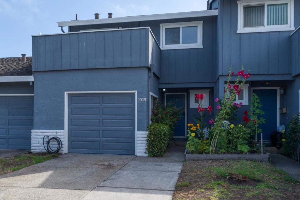 This charming townhouse in the Villa Cardoza Community of Half Moon Bay offers a convenient and comfortable lifestyle. It features a thoughtfully designed floor plan with an entry hall, half bathroom, modern kitchen with light cabinetry and ample storage, and a spacious living/dining area with dual French doors that add elegance and lead to an English garden oasis for outdoor dining and entertaining. The home has been recently refreshed with new interior paint. Upstairs, you'll find a primary bedroom with a walk-in closet, full bathroom, and two additional bedroomsone versatile room that can be used as an office with a balcony offering a glimpse of the ocean view. Suzanne Court provides access to a communal lawn area with mature trees, a BBQ area, picnic benches, and lush garden flowers. The attached one-car garage has been recently updated with coated flooring, includes laundry facilities, and extra storage cabinets. Located near coastal beaches, at the end of town, with easy highway access, this home is perfect for commuting to San Francisco and Silicon Valley while enjoying peaceful coastal living.
