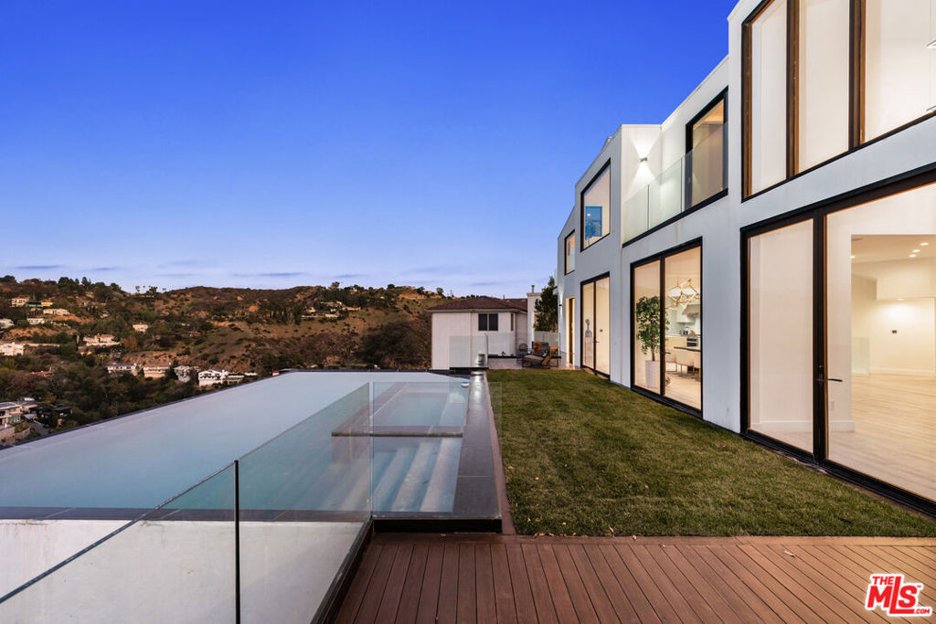 Available fully furnished and turnkey for short, midterm, or long term lease! Located in the heart of Hollywood Hills on a quiet street in the exclusive Mt. Olympus neighborhood. Just minutes away from sunset strip, this newly built luxurious modern masterpiece is the perfect dream home. Whether you seek thrills of Hollywood or prefer a quiet night at home w/ stunning views, this setting allows for access to all types of enjoyment and relaxation. Luxurious front entry pivot door opens to a bright open floor plan w/ hardwood floors & floor-to-ceiling Fleetwood glass leading to enormous 2,000 sq. ft. deck w/ jaw dropping zero-edge infinity pool/spa floating into the canyon. Perfect for indoor-outdoor entertainment w/ surround sound throughout the home. Master chef's kitchen, huge marble kitchen island, top-of-the-line appliances & Custom cabinetry from Italy. Home offers four bedrooms upstairs plus movie theater & sauna downstairs. Master suite features romantic fireplace, private deck, Spa like master bath & enormous dual walk-in closet. Canyon views from every room.