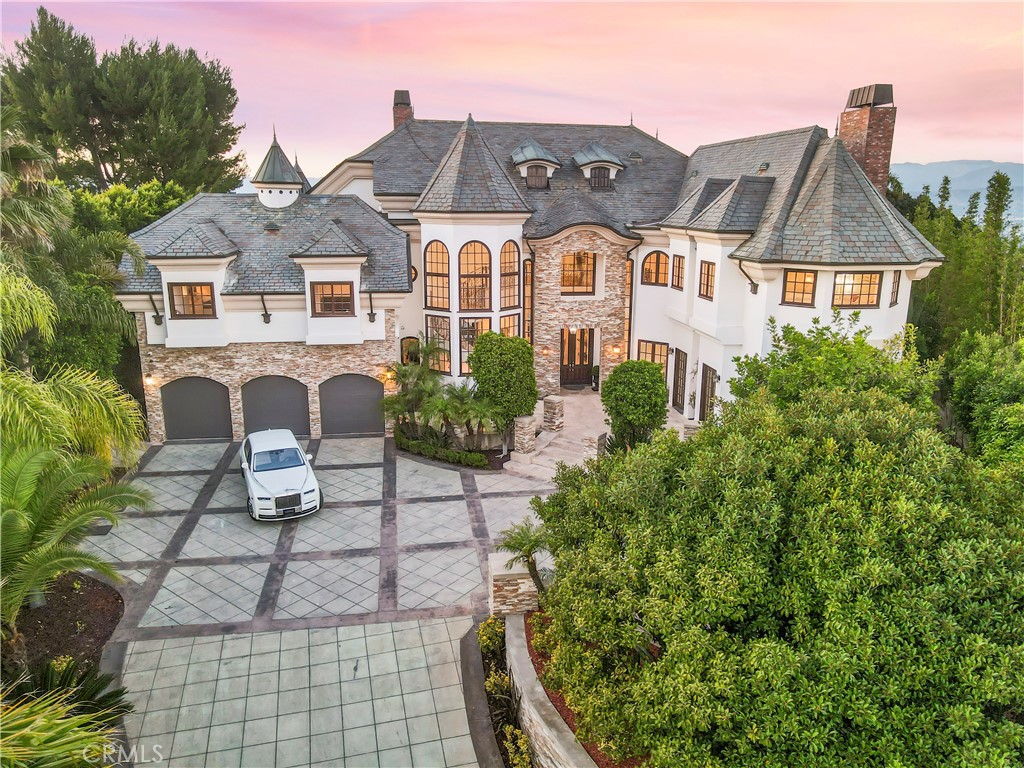 The Chateau of Beverly Hills. Perched atop the iconic Mulholland ridgeline, The Chateau of Beverly Hills is a French-inspired architectural masterpiece offering panoramic 360° views from the Pacific Ocean to Downtown LA and the Santa Monica Mountains. This ultra-private, gated estate combines timeless European elegance with modern California luxury. Spanning over 9,300 sq ft of refined interior space, this 5-bedroom, 7-bathroom residence is designed for elevated living and global entertaining. Enter through a grand double-height foyer with 30-ft windows and a dramatic floating staircase. Multiple formal and informal living spaces are enhanced by five fireplaces, custom limestone floors, and rich millwork throughout. The formal dining room sets the stage for world-class hosting, while the chef’s kitchen — framed by curved French windows — features a grand center island, premium appliances, and artisanal finishes. The primary suite is a private sanctuary with dual spa-like baths, dual dressing rooms, a soaking tub with skyline views, a romantic fireplace, and a private terrace suspended above the city lights. Additional highlights include a redwood-clad library, three living lounges, and an estate layout that balances scale with intimacy. Set on nearly ¾ of an acre, the manicured grounds feature a resort-style pool and spa, open-air kitchen with built-in BBQ, fireplace lounge, ambient waterfall, and a private sauna with shower — creating a five-star wellness experience at home. A 3-car garage and large motor court offer elegant convenience and security. This is not simply a residence — it is a rare legacy estate that captures the essence of Beverly Hills prestige and international distinction.