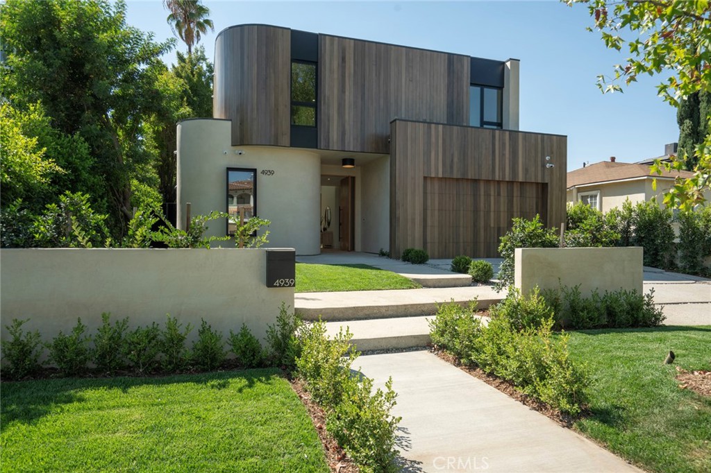 Enter an environment where the warmth of organic modern architecture meets stunning new luxury construction. Elegant 6BR + 5.5BA property sits on an almost 11,000 sqft lot + includes a 1BR + 1BA guest house w/its own address. Gorgeous open floor plan features sleek kitchen w/center island, quartz counters, white oak cabinets + stainless steel appliances including a Wolf 8 burner range w/double oven. Living room w/fireplace has huge sliders leading out to the extensive grassy grounds. Kitchen overlooks a private deck area w/Japanese landscaping. Both the kitchen + dining area have custom designed light fixtures. The gentle curves of the home's exterior can be found in details throughout the house, such as the fireplace, the curved corners of rooms + even the concrete steps throughout the exterior. The opulent primary suite has everything. Huge floor to ceiling windows slide open for viewing the amazing grounds. A separate area for lounging opens to a spacious side balcony. Two custom walk-in closets have extensive built-ins. Gorgeous primary bath w/soaking tub has an oversized shower w/dual rain heads + seating benches, plus double sinks + vanity area. Second level includes a sitting area/library w/dramatic skylight + 2 more ensuite BR's. An airy floating staircase connects the two levels, w/another 2BR + 2BA below. The grand living space is accentuated w/high ceilings, extensive use of glass + is infused w/a spectacular amount of natural light. Step outside + encounter the exceptional park-like oasis. An immense pool w/spacious baja shelf also includes a spa. Amazing outdoor entertaining area features stainless steel BBQ, a smoker, a refrigerator, a pizza oven, stainless steel sink + tons of cabinets. At the back of the private grounds sits the jewel of the property - a 1BR + 1BA ADU with 800 sqft that looks like a mini version of the main house, w/the same unique wood exterior + curves inside + out. The floor plan includes an extensive kitchen w/quartz center island + living room. It would make a great office or a multi-generational compound. The living space sliders completely open to the patio creating a perfect indoor outdoor flow. Its view looking out over the grounds + backside of the main house creates a dramatic backdrop for everyday living. This is a one of a kind property. Come satisfy your appetite for something new + break away from all the "modern farmhouse" + "modern box" replicants. And experience over 6,100 sqft of new architectural luxury.