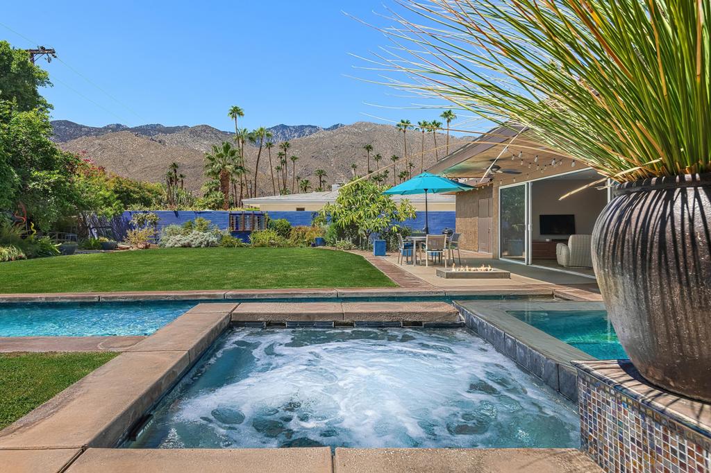 South facing backyard with captivating mountain views! Welcome to a stunning Mid-Century oasis in the heart of Deepwell Estates, positioned on one of the neighborhood's most coveted streets. This beautifully preserved home, lovingly maintained by the same family for over two decades, combines classic elegance with modern sophistication, reminiscent of the famed Trousdale designs. As you enter, you'll be captivated by a striking 40-foot glass wall, perfectly framing the exquisite view of a uniquely designed pool and mountain vistas. The open-concept floor plan seamlessly connects the main living area, dining room, family room and kitchen -- creating an ideal setting for entertaining family and friends. The kitchen was enlarged and reimagined to become a visually sophisticated and highly functional space with plenty of cabinets, center island, gas cooktop, double ovens and built-in bar area. The spacious primary suite offers sliding glass doors that open directly to the pool and frame the breathtaking mountain views. The primary bathroom is a luxurious retreat featuring a double vanity, zero-entry shower, and an exterior door for convenient access to the outdoor shower and pool. Two additional well-sized bedrooms include one en-suite, perfect for guests and family. The expansive backyard has room to roam with several seating and entertaining areas all complimented by a row of citrus trees, firepit and dramatic mountain views. Recent enhancements, include a resurfaced roof in 2024, variable-speed pool pump in 2022, owned solar panels with inverter in 2021, updated electrical, plumbing, dual pane windows, Fleetwood sliders and heat pumps highlighting the home's enhanced functionality ensuring cost-effective living. This exceptional residence, located within one of Palm Springs' most beloved neighborhoods, perfectly captures the essence of desert living. This home radiates the Palm Springs lifestyle you've been waiting for!