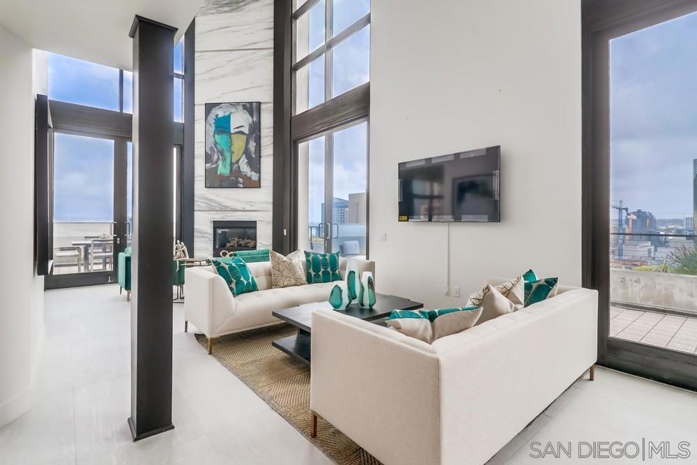Crowning the Renaissance tower in the Marina District, this two level penthouse delivers sky-high luxury with 4 bedrooms, 6 baths and approximately 4,391 square feet of designer remodeled and furnished interiors. Wide plank hardwood, 18 by 36 porcelain tile, custom cabinetry, curated lighting and premium fixtures set a refined tone throughout. The dramatic living and dining great room rises to 20 foot window walls and showcases a marble clad fireplace, while sliding glass doors open to a spectacular wraparound terrace of more than 1,400 square feet that frames unobstructed views over San Diego Bay, the Pacific, Point Loma, Coronado and the city skyline. The gourmet kitchen offers professional appliances, slab stone counters, a breakfast nook and space for a full wine refrigerator, and an adjacent entertainment lounge features a full bar. A guest suite with fireplace and ensuite bath plus a private office sit on the main level. Upstairs, the primary retreat enjoys its own fireplace, boutique closet, dual vanities, sauna, oversized jetted tub and glass shower, while a loft style guest suite provides a sitting room, fireplace and spa bath with steam shower. Residence includes two side by side parking spaces and a storage room. Renaissance amenities encompass a twenty four hour concierge, pool and spa, fitness center and barbecue courtyard, all moments from Seaport Village, the Gaslamp Quarter and Petco Park. This is true penthouse living with no neighbors above and nothing comparable downtown.