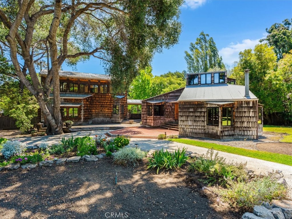 A generous and secluded gem, this late mid-century “Sea Ranch” style retreat property will transport you to the sensation of Big Sur. Designed and built by the visionary owner, the parcel includes a guest house, detached garage “barn,” pumphouse, and 1940’s (est.) greenhouse with glass panes. The main house has open beams, metal work by local artisans, library loft. The detached wing includes primary bedroom with en suite and also has an extraordinary upstairs studio with custom plumbed darkroom. The exterior of the structures is clad with sugar pine shakes. The guest house has an open frame ceiling, with original wood flooring and charming loft area, and includes a ¾ bath. The 50-foot heated lap pool and expansive lawn areas, are remarkable highlights. Cerro San Luis Mountain frames the horizon to the west and the Santa Lucia Range to the east. The bordered and terraced garden sections, with repurposed concrete edges are an oasis for your green thumb. Glorious established fruit trees include fig, plums, and citrus varieties including lemons, mandarins, oranges, and lime. All this delightful peace and privacy is within the Anholm district, and less than a mile to the heart of downtown San Luis Obispo. Abundant area for onsite and off-street parking. Location is also ideal for access to sought-after schools, proximity to recreation and open space. Per owner, main house and bedroom wing have 2638 sq ft, guest house has 744 sq ft.