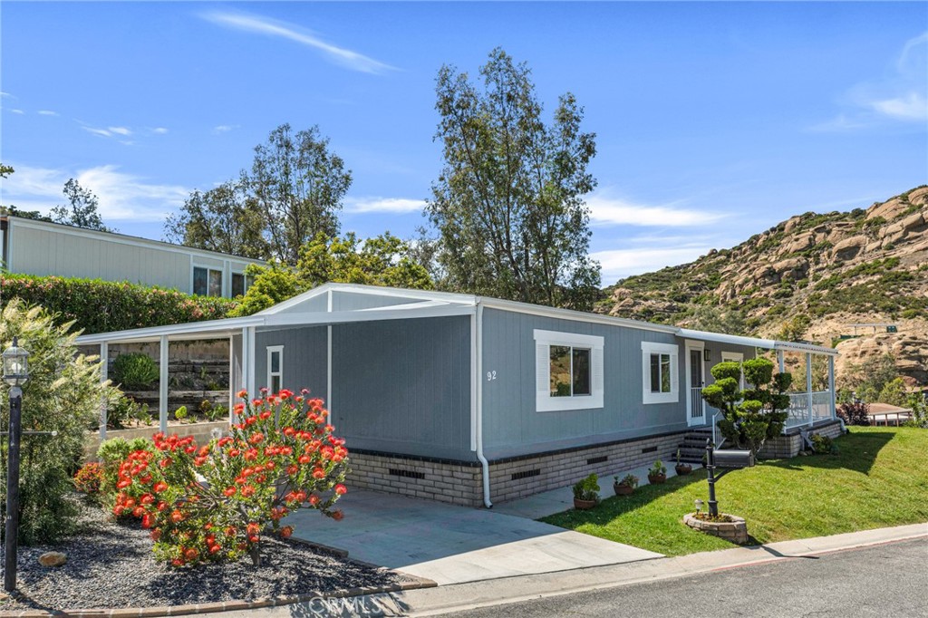 Discover this fully renovated and upgraded 2-bedroom, 2-bathroom manufactured home located in the Summit gated community in West Hills. With 1,152 sq ft of modern living space on a uniquely large lot, this home is surrounded by panoramic mountain views and features a welcoming front patio, perfect for outdoor relaxation and entertaining. From top to bottom, this home has been thoughtfully updated with high-end finishes and major system improvements that add lasting value. Outside, you’ll find a new carport, newer roof, newer rain gutters, fresh exterior paint, and drought-resistant landscaping. The front yard is equipped with a sprinkler system, while the backyard features a drip irrigation system and a large storage shed. Step inside to a bright, modern open floor plan enhanced by new recessed lighting, new high-quality wood-like flooring, and new interior paint. The fully upgraded kitchen is a showstopper, featuring wood countertops, a spacious center island, and top-of-the-line finishes perfect for everyday living and entertaining. Every window has been replaced with double pane insulated windows, and the home includes new drywall throughout for improved insulation and a fresh, clean feel. Both bedrooms have been fully updated with large closets and scenic views, with one serving as a private ensuite for added convenience and privacy. The two beautifully renovated bathrooms feature modern finishes throughout, including elegant vanities with LED mirrors, sleek medicine cabinets, updated fixtures, plenty of storage space, and in the ensuite, a separate soaking tub for a spa-like retreat.You’ll also appreciate the convenience of a separate, updated laundry room—a rare and valuable feature. Additional major upgrades include a new plywood subfloor, copper plumbing, new water heater, and a newer HVAC system, providing energy efficiency and peace of mind for years to come. As part of The Summit community, enjoy access to fantastic amenities such as a recreation center, pool, spa, picnic area, and RV parking. This home is truly move-in ready with extensive new and newer features throughout—offering style, comfort, and unmatched value. Don’t miss this opportunity!