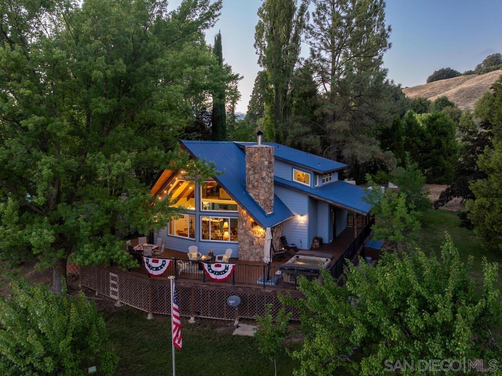 Welcome to 1209 Farmer Road, a scenic mountain retreat offering a rare blend of serenity, adventure, and opportunity in the heart of Julian. Newly remodeled in 2020 with an additional 720 sqft., the expanded layout includes a loft, family room, guest bedroom, and ensuite. The home is equipped with a seller-owned solar system featuring 18 panels and a hard-wired Generac generator for energy efficiency and peace of mind. The property boasts two producing wells with iron filtration systems, a dedicated RV site with 30-amp electrical and septic hookups, a detached two-car garage, an approximately 20x20 workshop, two pump houses, multiple outdoor sheds, and a barn, ideal for livestock, storage, or business use. Metal-Gated and fully fenced. Set beside the Volcan Mountain Preserve Trail, this location offers direct access to one of Julian’s most cherished hiking trails. The grounds include a producing apple orchard with Empire, Golden Delicious, Honeycrisp, Jonathan, and Liberty varieties. U-pick dates run from September 20–28. Additional fruit trees include cherry, apricot, and pear, and raised garden beds. Located in an International Dark Sky Community, enjoy breathtaking panoramic views on the expansive maintenance-free TREX deck, by day and awe-inspiring stargazing by night. Just minutes from Julian’s historic townsite, local wineries, restaurants, Lake Cuyamaca, and popular camping destinations, the property offers both privacy and tranquility. Whether you're seeking a full-time residence, weekend escape, or income-producing retreat, this extraordinary property has it all. Five (5) HVAC Spit Units, Tankless Water Heater.
