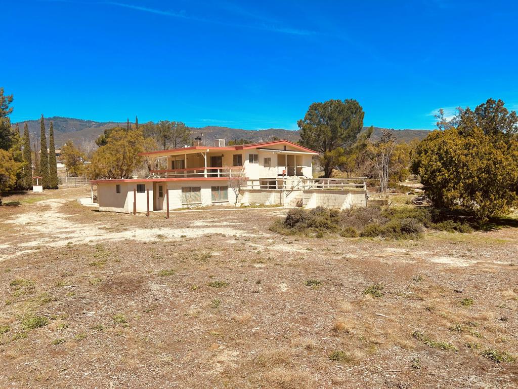 Enjoy being tucked away in a quiet and peaceful location just off paved Mitchell Rd. This property has so many great features and is close to schools and town. The first impression is of solid build block construction. The home is a split level with the main home consisting of 2 bedrooms each with their own sliding door access to the outside. Master bedroom has his and her closets, bathroom, and a handicap ramp adjoining the sliding glass door. The living area connects to a nice open kitchen with vaulted ceilings boasting stately wood beams. A cozy wood stove is next to the opening of a great covered rooftop patio overlooking the property. Down the steps outside you will gain access to another very large room for a 3rd bedroom or many other possibilities. This room has a bathroom just across a breezeway and connects to the oversized 2 car garage. There is also a separate cedar paneled laundry room with spanish tiled floor that can house a spa and has hookups. Outside, the property is fully fenced. There are storage sheds, nice shade redshank and pine trees, and a park-like atmosphere. Come taste a little bit of country and bring your animals to enjoy this over one acre of usable land.