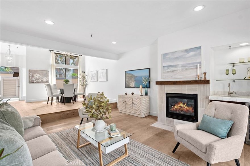 Experience resort-style living in the heart of Newport Beach with this beautifully remodeled residence in this coveted gated community, offered at an incredible value. Blending contemporary design with timeless elegance, this home offers a warm and inviting atmosphere, enhanced by abundant natural light and thoughtful finishes throughout. The open-concept main level welcomes you with a stylish dining area, a spacious living room anchored by a sleek fireplace, and a built-in wet bar with wine refrigerator — perfect for entertaining. Glass doors open to a generous back patio, creating an effortless flow between indoor comfort and outdoor enjoyment. A second, enclosed front patio off the kitchen provides a sunny spot for morning coffee or al fresco dining. The modern kitchen features a center island, ample storage, and a picture window overlooking the private courtyard. This two-bedroom, two-bathroom home includes a main-level guest room and full bath, ideal for visitors or a home office. Upstairs, the serene primary suite boasts a private balcony, a spa-inspired bath with dual sinks, and crisp, modern finishes. Residents enjoy resort-style amenities including a sparkling pool, spa, and tennis courts, all set amid lush, landscaped grounds. Two secure underground parking spaces are included. With world-class beaches, upscale shopping and dining at Fashion Island, John Wayne Airport, and major freeways just minutes away, this property offers an unmatched combination of style, comfort, and convenience in one of Orange County’s most sought-after locations.