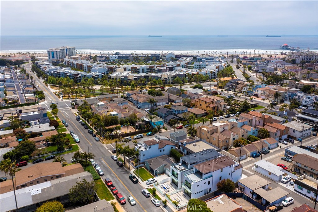 Recently constructed in 2021 with Views of the Hotels from the rooftop decks, 209 Huntington Street offers an unrivaled lifestyle just 3 blocks from Pacific City Mall, Premier Hotels and a very short walk to the iconic Huntington Beach coastline. Situated on an oversized lot, this incredible 3,303 square foot home delivers an exceptional front patio with gas fire pit and pristine landscape architecture. The depth and width of the elevated lot also provides for a rare 2-3 car driveway in addition to the 2-car garage. Upon entry, you are greeted into the completely open concept floor plan that flows seamlessly from the chef's kitchen, through both spacious living areas with a warm fireplace and outdoors through panoramic bifolding doors to the massive outdoor entertainer’s patio. Custom appointments include coastal porcelain tile flooring on the lower level, wood flooring throughout the second and third levels, ELEVATOR ACCESS to all three levels and designer paint colors and lighting fixtures throughout. Your enviable kitchen showcases painted white cabinetry, top of the line stainless steel appliances, chic Quartz countertops and a stunning island with bar top seating for 4. Traversing to the second level, your master bedroom suite showcases a fireplace, panoramic doors to a private balcony, a walk-in closet with custom built-ins, a deluxe master bathroom with soaking tub, separate glass enclosed shower and his and hers vanity area. A flex office/loft space on the second level is perfect for working from home. Two additional guest bedrooms are privately situated on the opposite wing of the home and share one of the three full bathrooms. Your versatile Third level bonus room with a third full bathroom exits to two roof top decks through panoramic doors. Both decks offer California room style covered areas and open deck space to enjoy the views, sun and coastal breezes. This is an exceptionally rare property that will not last.