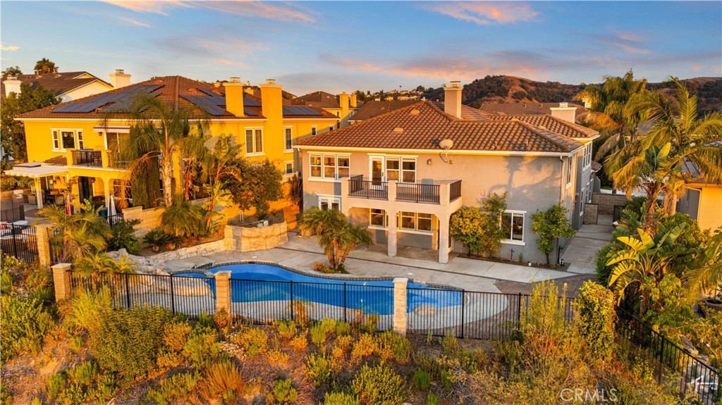 VIEW, VIEW, VIEW! Panoramic 180-degree view, a sparkling private pool & spa, and timeless elegance define this luxury home in the prestigious 24-hour guard-gated community of Diamond Hill Ranch.
Featuring 5 bedrooms, 4 bathrooms, a large open loft, an open entertainment room, and a dedicated office, the flexible floorplan includes 2 bedrooms and 1 full bathroom on the main level—ideal for multi-generational living.
Upon entry, you’re welcomed by soaring ceilings, a grand formal living room with dual-sided fireplace, and a spacious formal dining room. A walk-in pantry off the dining area provides ample storage and convenience.
The gourmet kitchen is equipped with granite countertops, a center island, and ample cabinetry, opening seamlessly to the family room and backyard with breathtaking views.
Upstairs, the expansive primary suite includes a private balcony with sweeping views, a luxurious en-suite bath with soaking tub and separate shower, and two walk-in closets offering generous storage.Additional highlights include an upstairs laundry room, dual-zone central AC, and a 3-car garage with built-in cabinetry.
The beautifully landscaped yard is an entertainer’s paradise—complete with a pool, spa, waterfall feature, citrus trees, and palm trees. A covered patio provides the perfect setting to enjoy the incredible sunsets.
This rare offering in one of Diamond Bar’s only two 24-hour guard-gated communities combines comfort, scale, and serenity in one extraordinary home. Come experience the lifestyle you deserve.
Broker and broker's agents do not represent or guarantee accuracy of the square footage, bedroom / bathroom count, lot size, and/or any other information concerning the conditions or features of the property. Buyer/Tenant is advised to independently verify the accuracy of all information through personal inspection & with appropriate professionals to satisfy themselves.