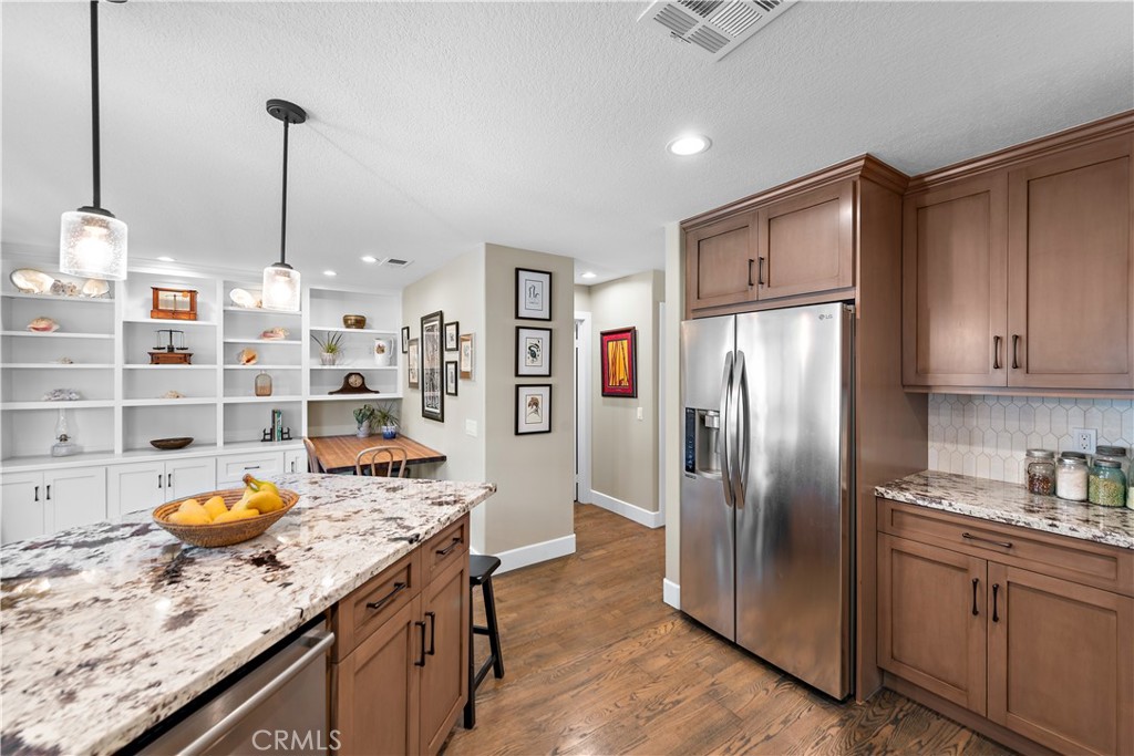 Nestled in the heart of Dana Point, 33121 Ocean Ridge is a fully remodeled masterpiece that beautifully combines modern elegance with coastal charm. This unit has been completely refurbished and lovingly maintained, offering a true turn-key opportunity. Upon entering, you're welcomed by a sunlit kitchen that captivates with gorgeous granite countertops, a stylish tile backsplash, and a striking copper hood that serves as the room's focal point. Custom cabinetry with soft-closing hinges and pull-out drawers adds sophistication, while solid wood floors flow seamlessly throughout, enhancing the home's inviting ambiance. Vaulted ceilings and can lighting create a sense of openness and warmth, perfectly complemented by new windows that flood the space with natural light. The new gas fireplaces add a cozy touch, especially in the incredible great room, ideal for both entertaining and relaxing by the fire. Outside, the home's location is unbeatable—just a short bike ride from downtown Dana Point, the picturesque harbor, and an array of fine dining and boutique shopping. The community offers exceptional amenities including a pool, two spas, tennis court, and a guard-gated entrance. It is also located just two miles from the stunning Strands Beach, and within walking distance to award-winning schools. With luxury, convenience, and comfort all in one, this home is ideal for quiet evenings, hosting friends, and embracing the best of coastal living.