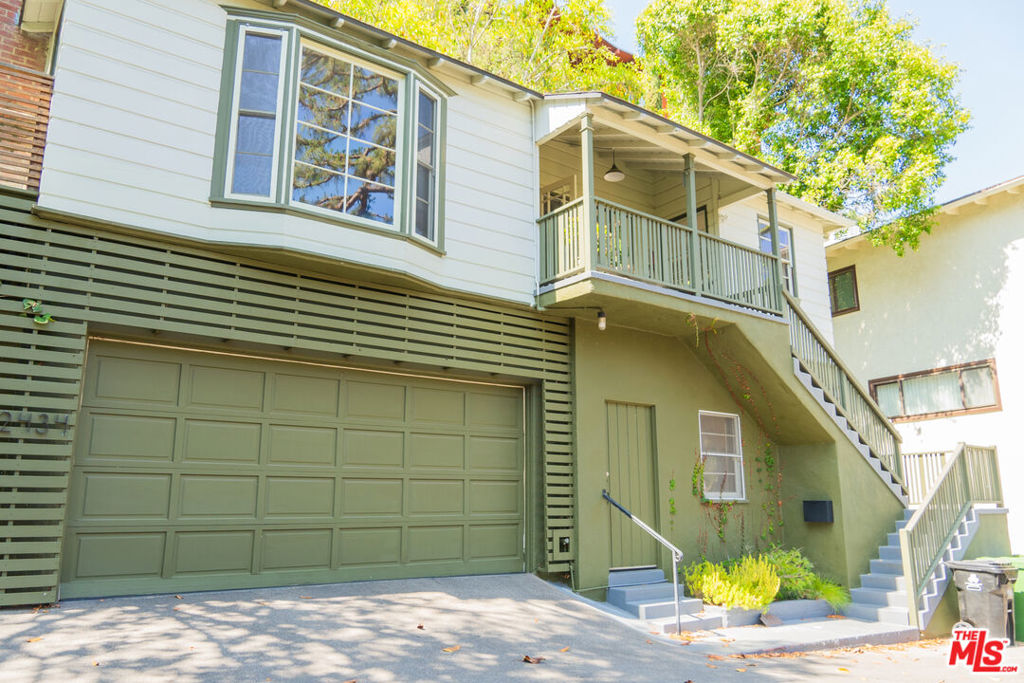 Welcome to 1940s Los Feliz charm, reimagined for modern living! Tucked away on a quiet cul-de-sac in the coveted Oaks neighborhood, this updated Colonial-style home offers a rare blend of privacy, history, and access to nature. Surrounded by mature trees and greenery, it's a peaceful retreat in the heart of the city. An expansive, inviting front porch overlooks the neighborhood below and sets the tone for what's inside. The home features hardwood floors throughout, a wood-burning fireplace, and a striking bay window that fills the living room with natural light. A spacious formal dining room flows into a remodeled kitchen, ideal for gatherings and everyday living. The primary bathroom retains its original vintage tilework, a nod to the home's enduring character. Outdoor living shines with a large deck for relaxing or entertaining and a stunning observation deck perched atop the hillside perfect for taking in views of Los Feliz and the surrounding hills. The downstairs third bedroom includes a separate entrance, creating a great opportunity for an ADU or private guest suite. Storage is plentiful with generous closet space, a tall two-car garage, an attic, and a crawl space ideal for a wine cellar. All this just blocks from Griffith Park and the shops and restaurants of Franklin Village.